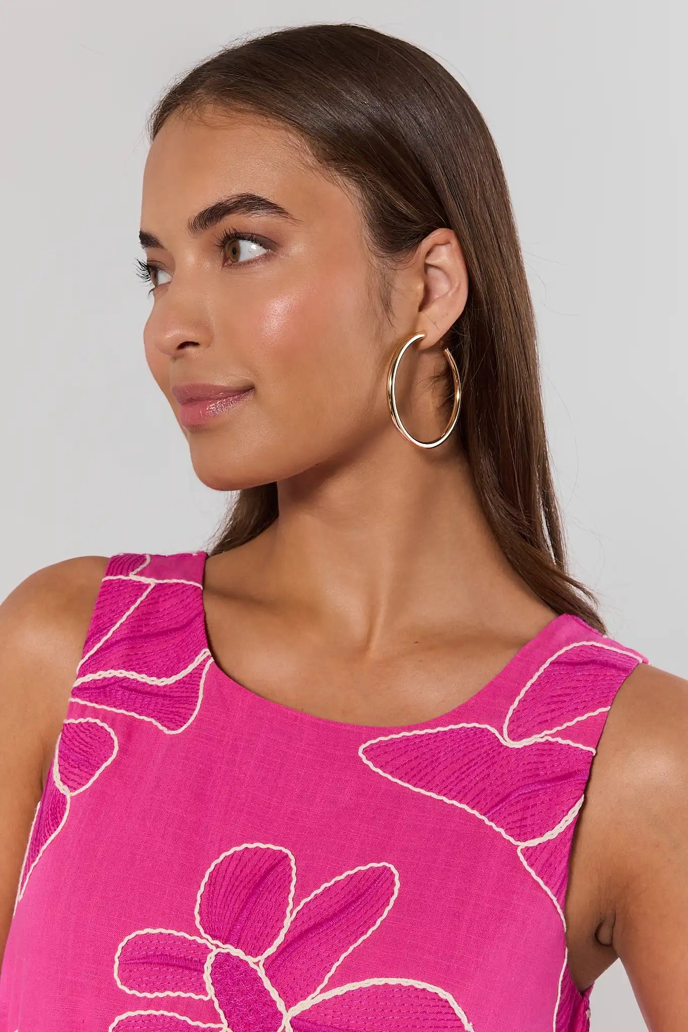 Woman wearing a pink floral dress against a plain background