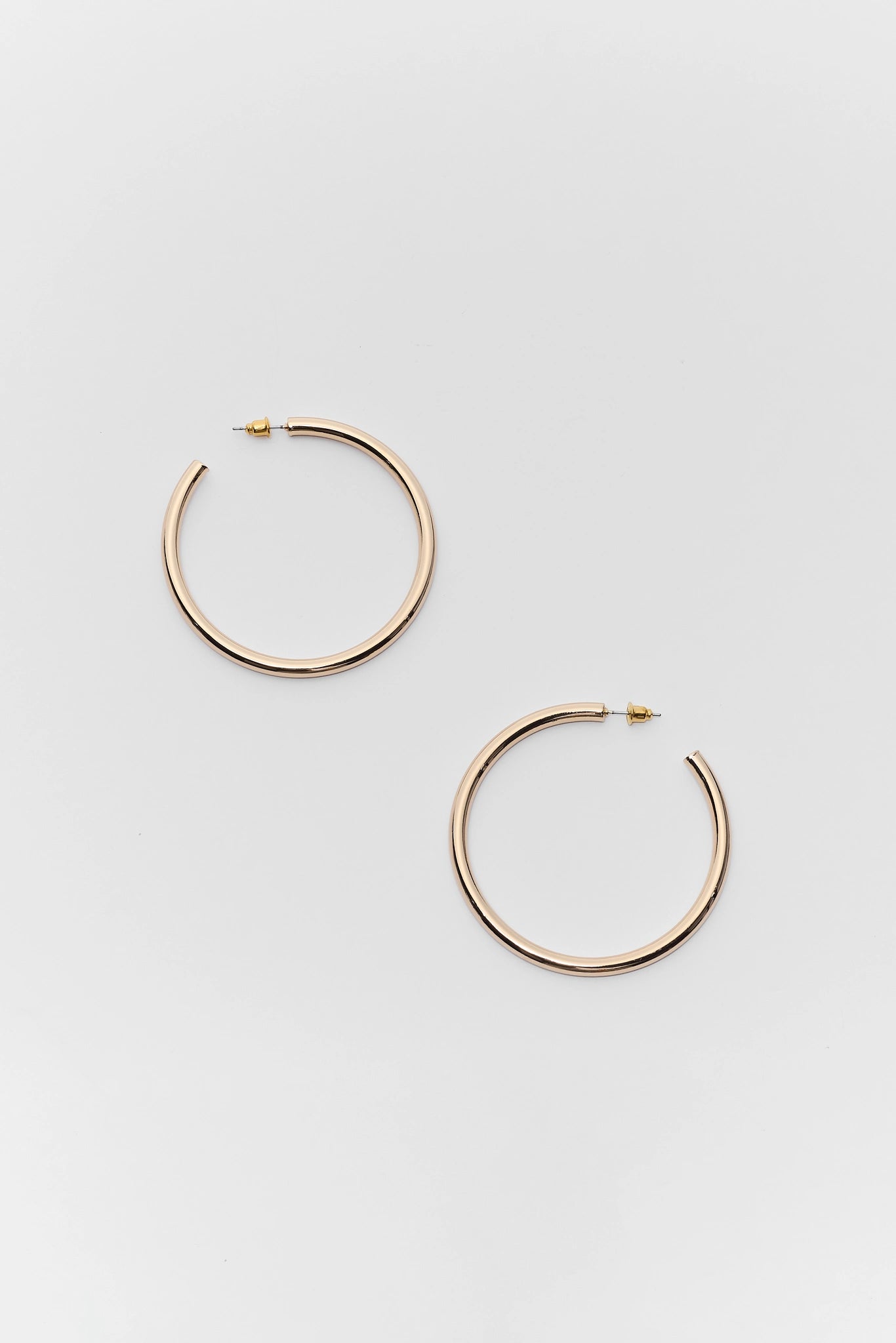Gold hoop earrings on a light gray background
