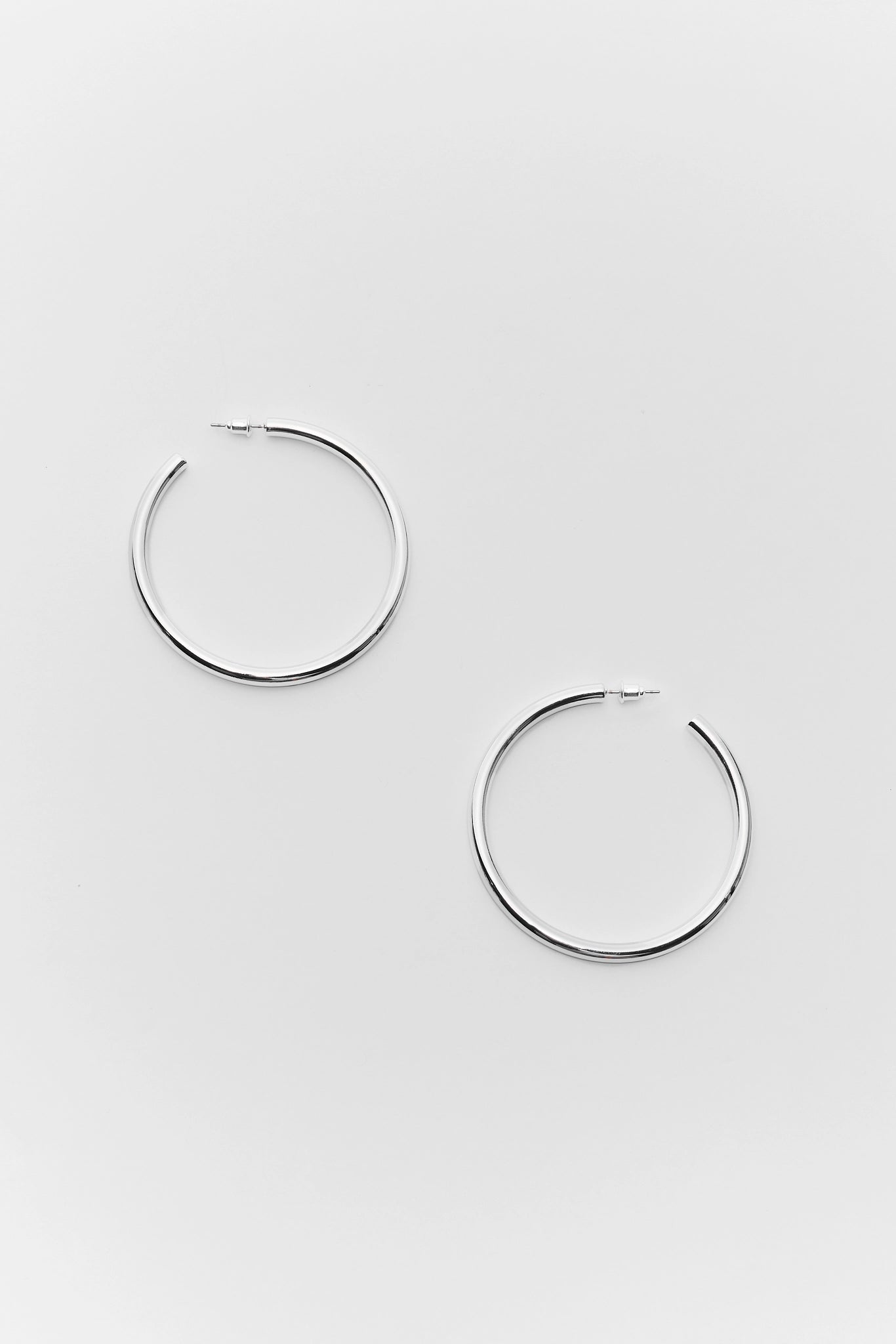 Pair of silver hoop earrings on a light gray background