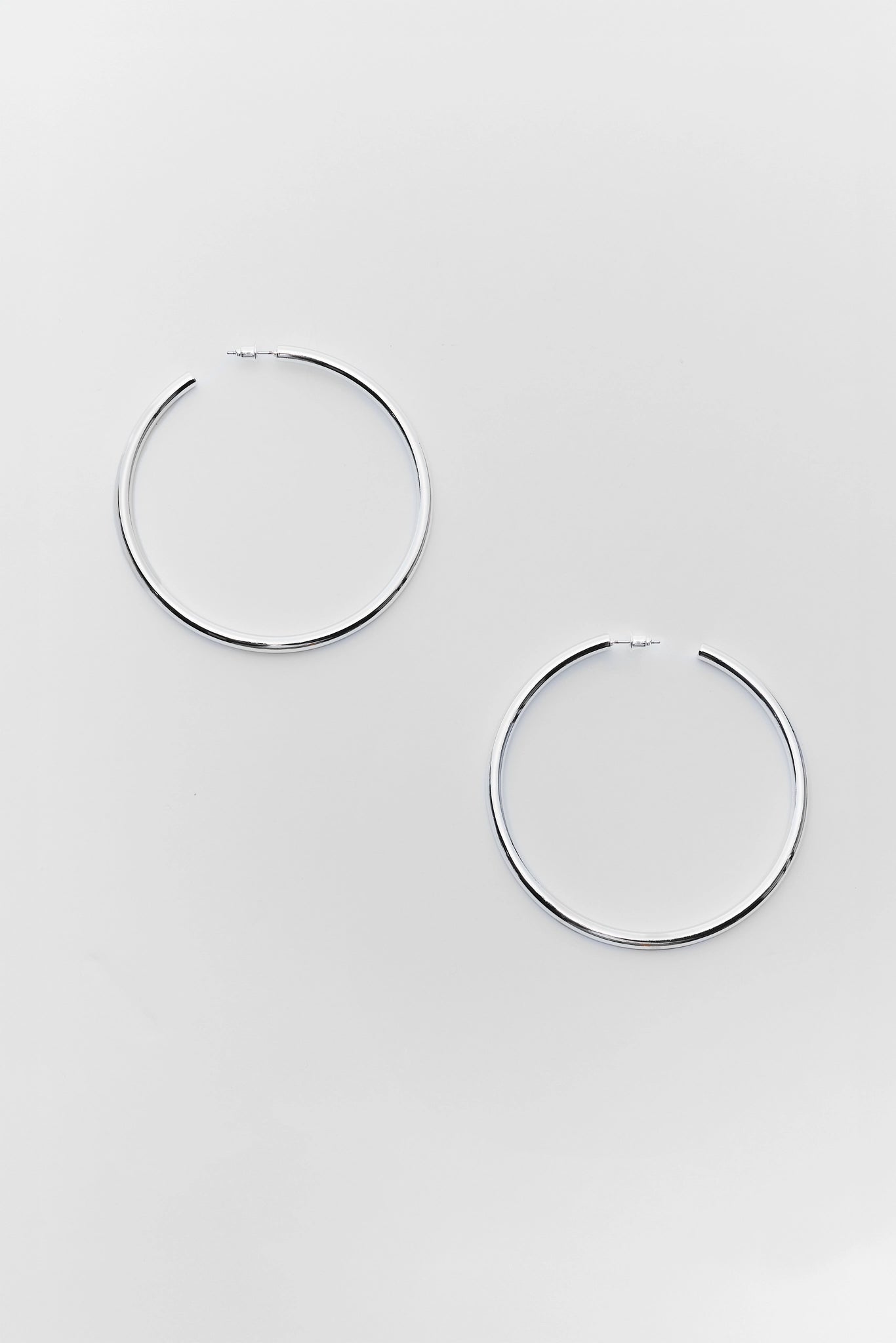 Pair of silver hoop earrings on a light gray background