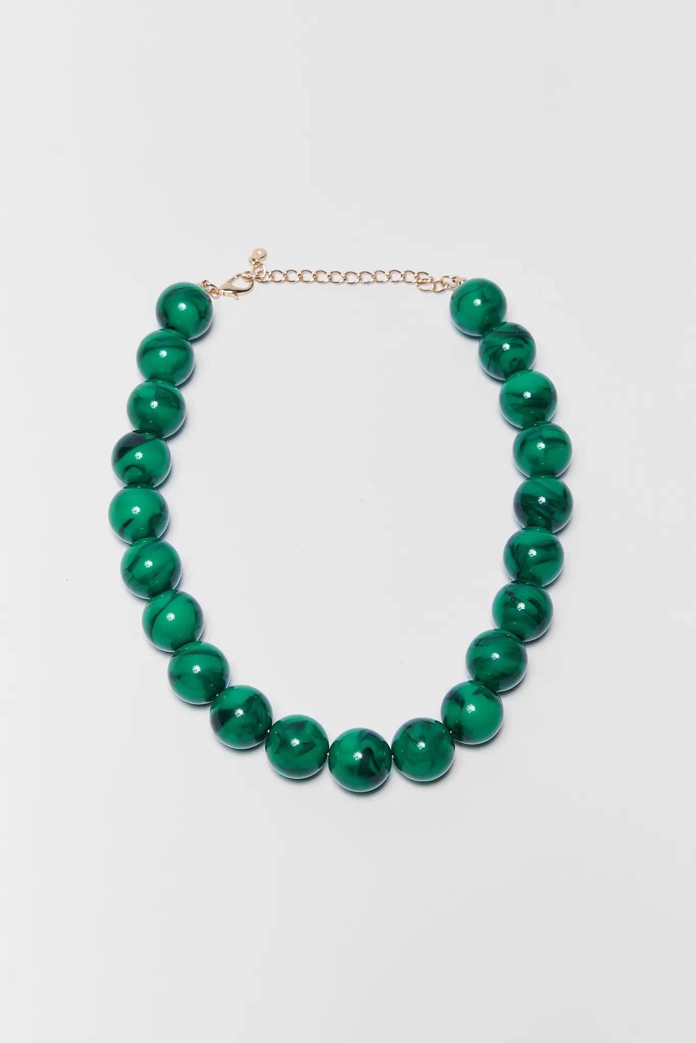 Green beaded necklace on a white background