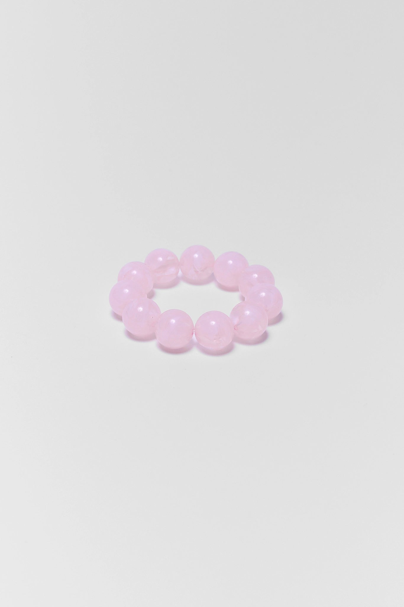 Pink beaded bracelet on a light gray background