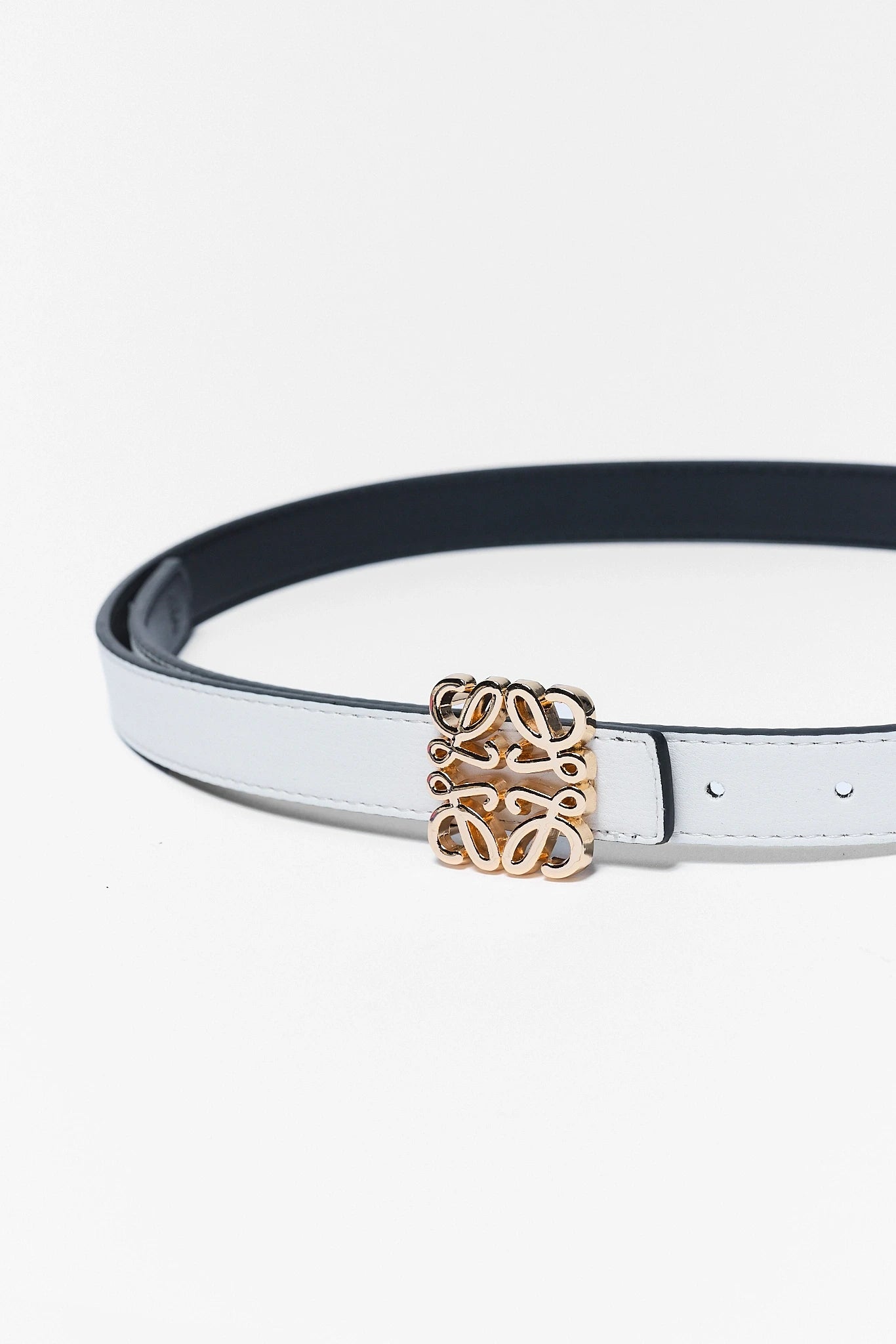 close up White rowan belt with a gold buckle on a white background