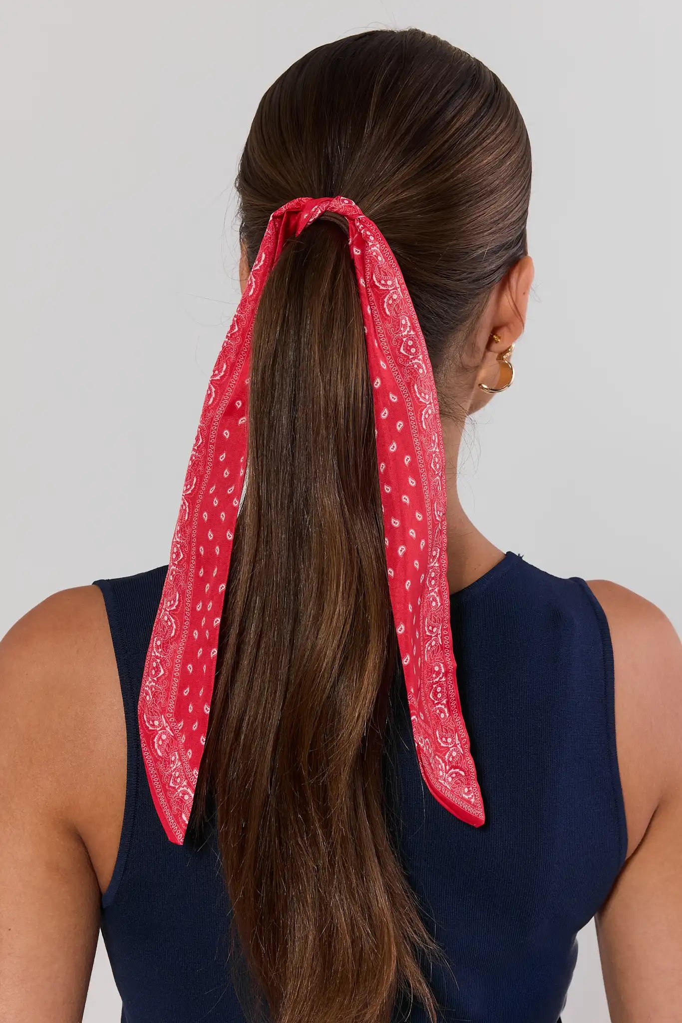 woman wearing Red patterned scarf on a light gray background