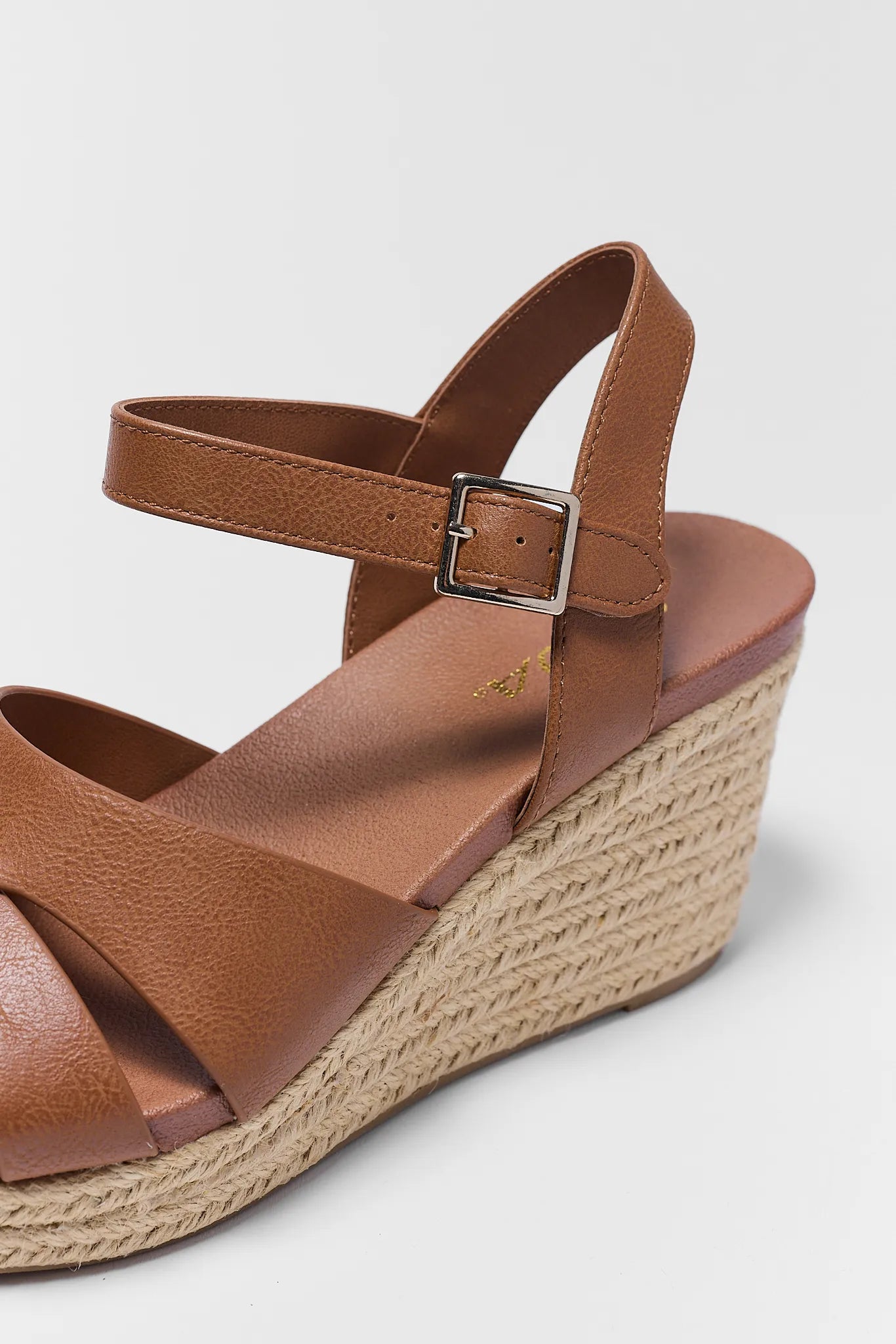 Brown wedge sandal with espadrille sole on a light background
