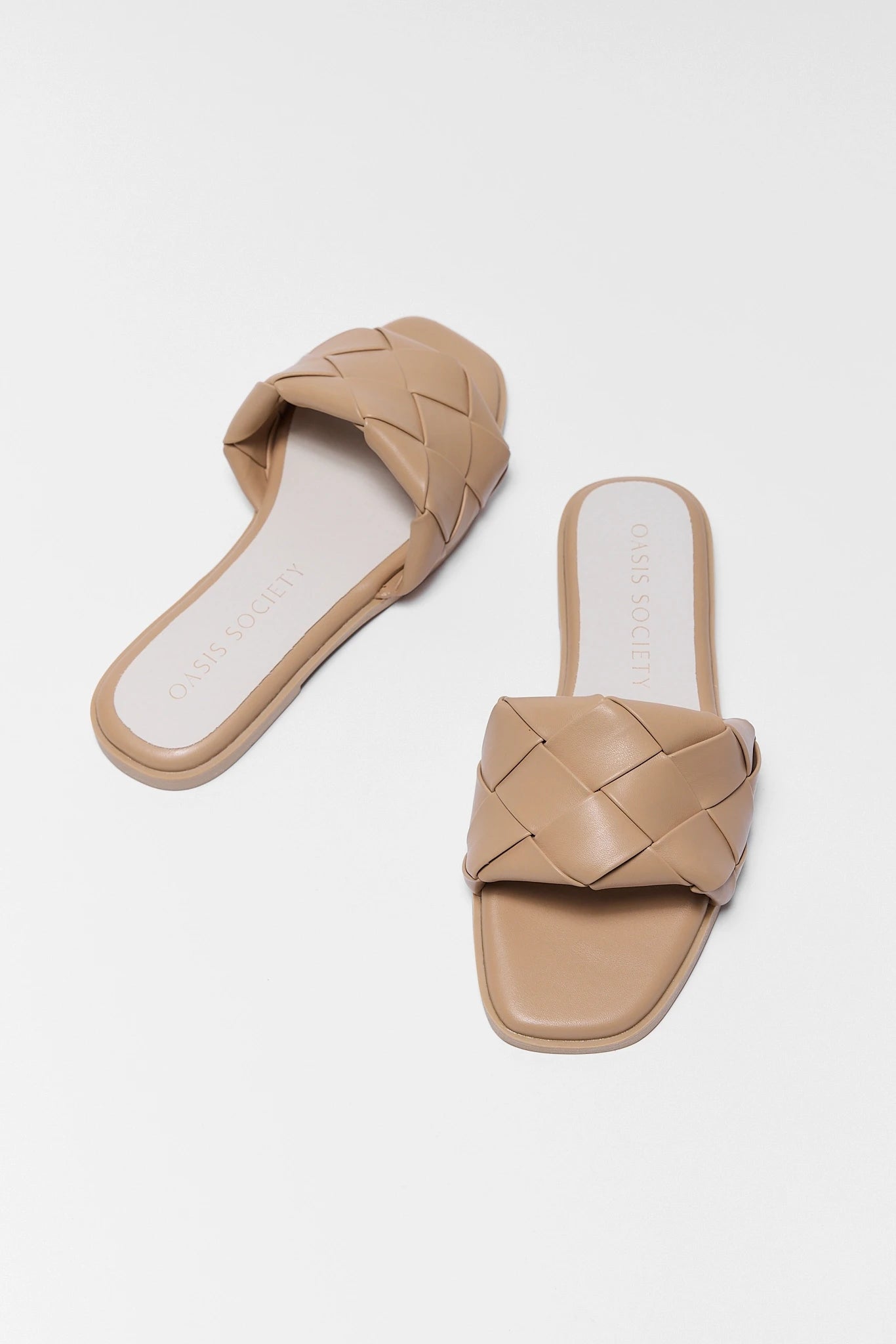 Pair of beige woven sandals on a white background two