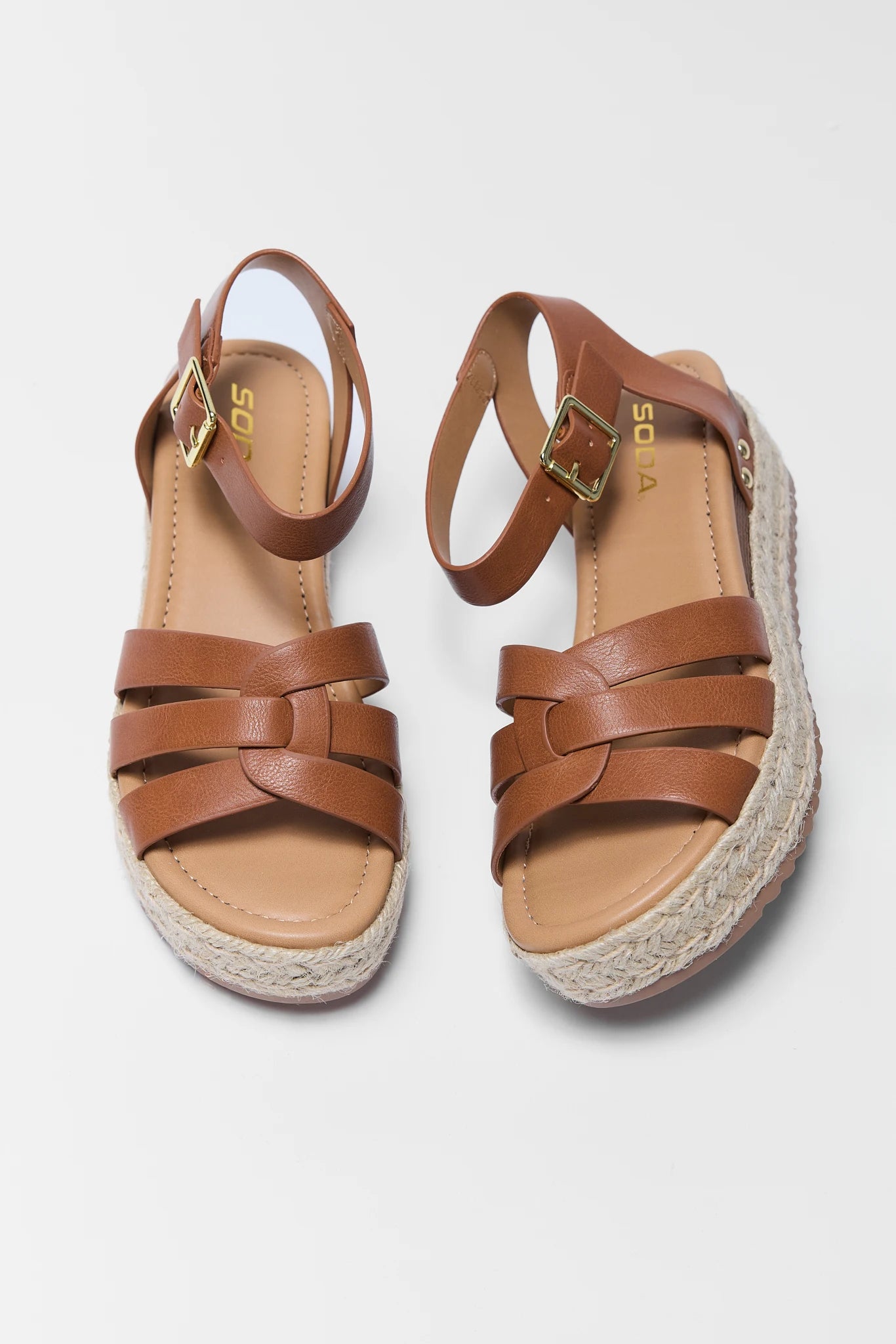 Pair of brown sandals with espadrille sole on a light gray background two