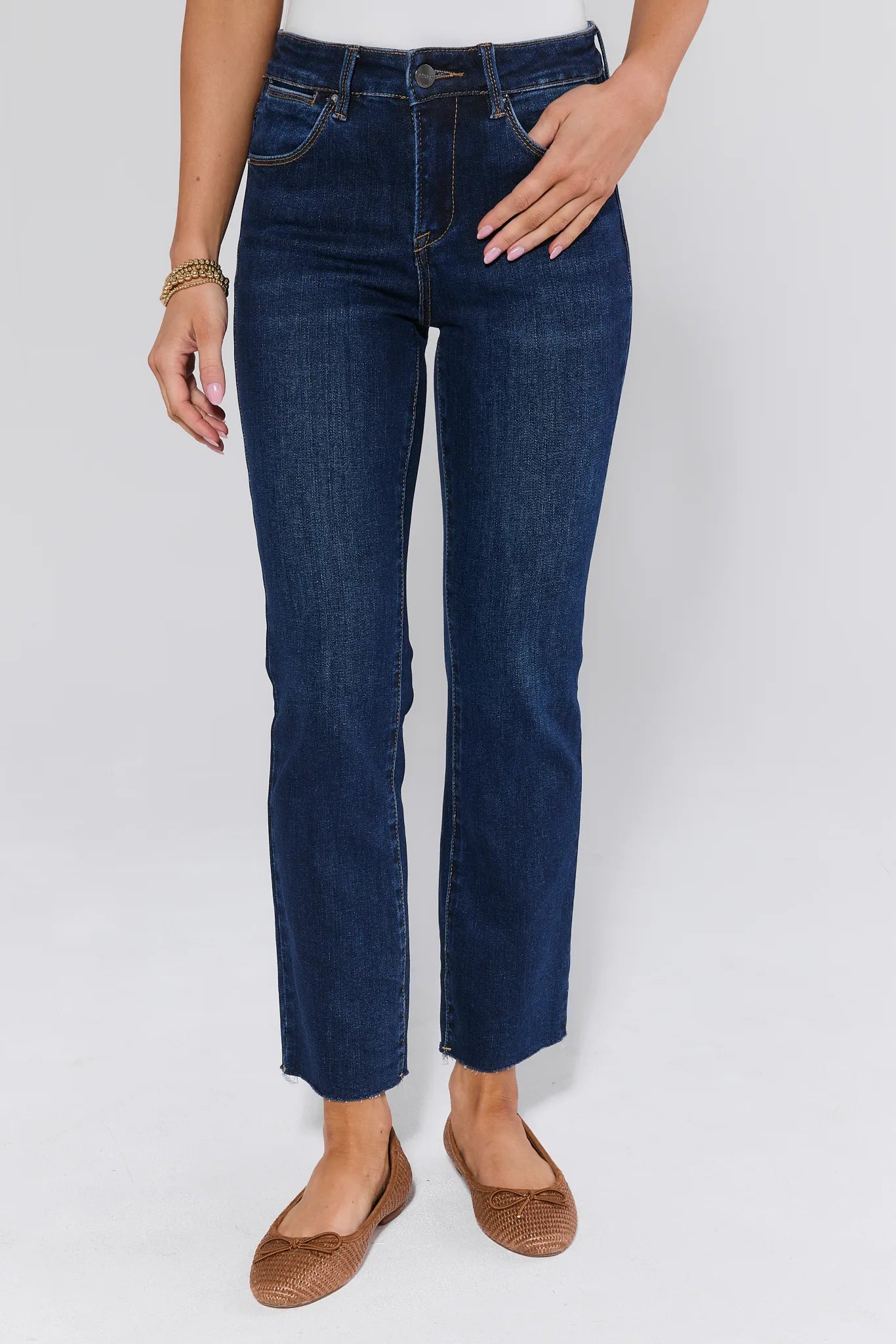 Person wearing dark blue jeans on a white background facing front 