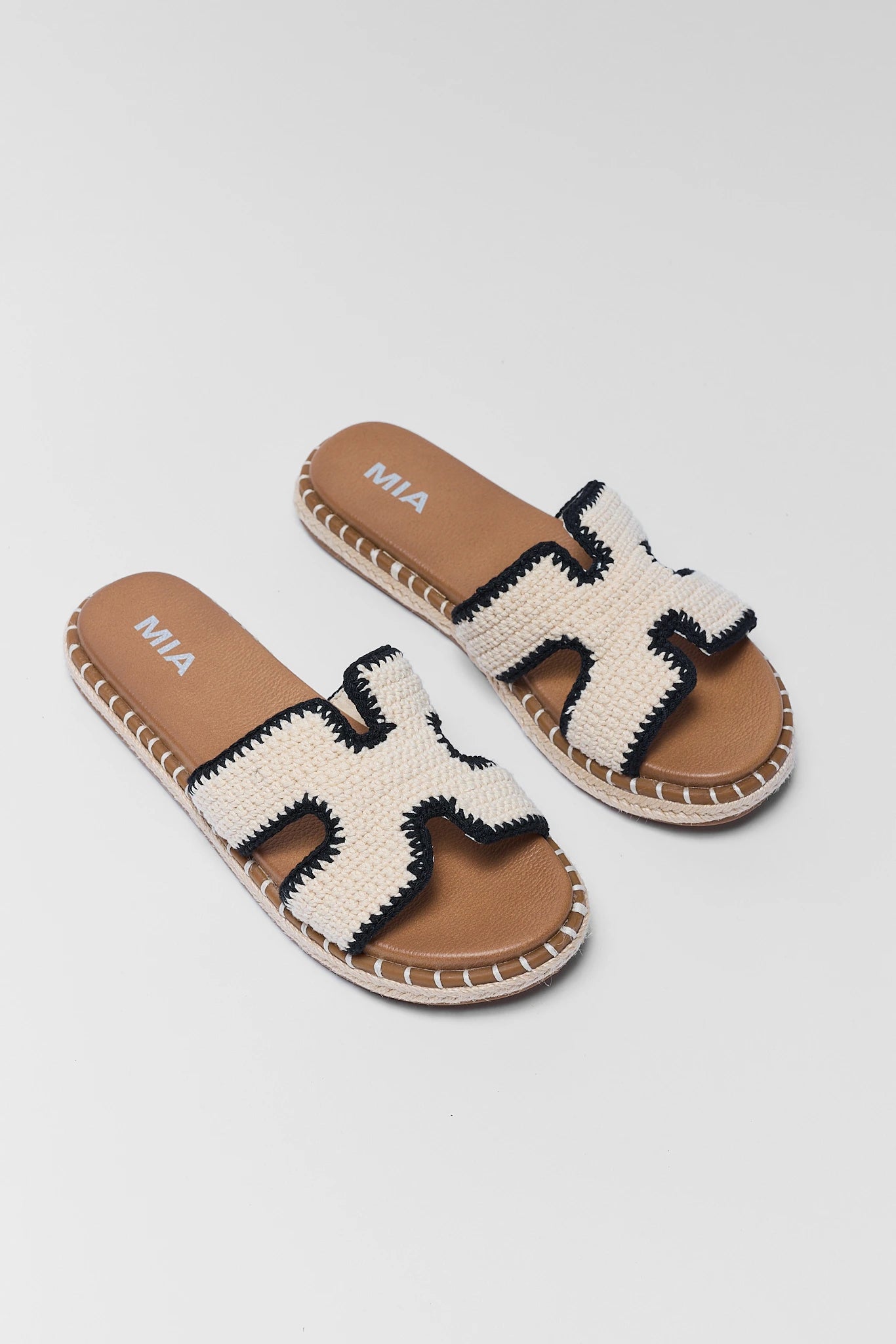 Pair of two sandals with woven design on a light gray background