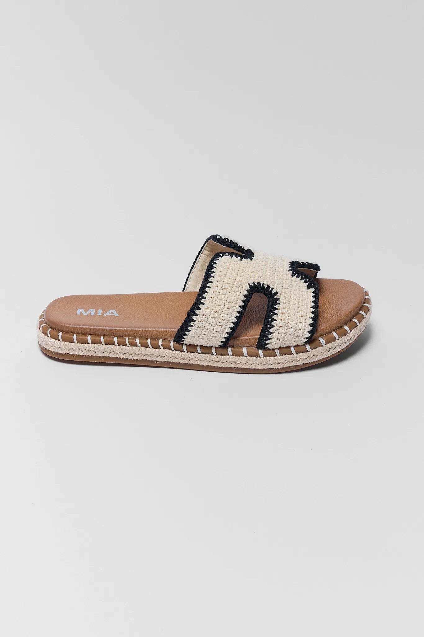 one Woven sandal with brown sole and white strap on a light gray background