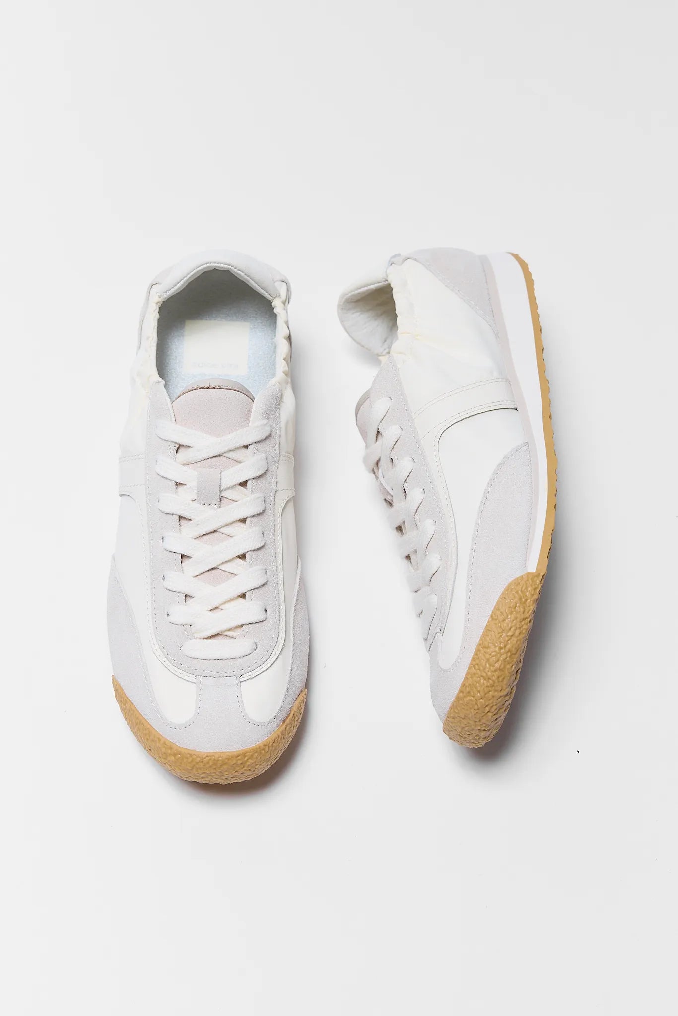 white sneakers with tan soles on white background