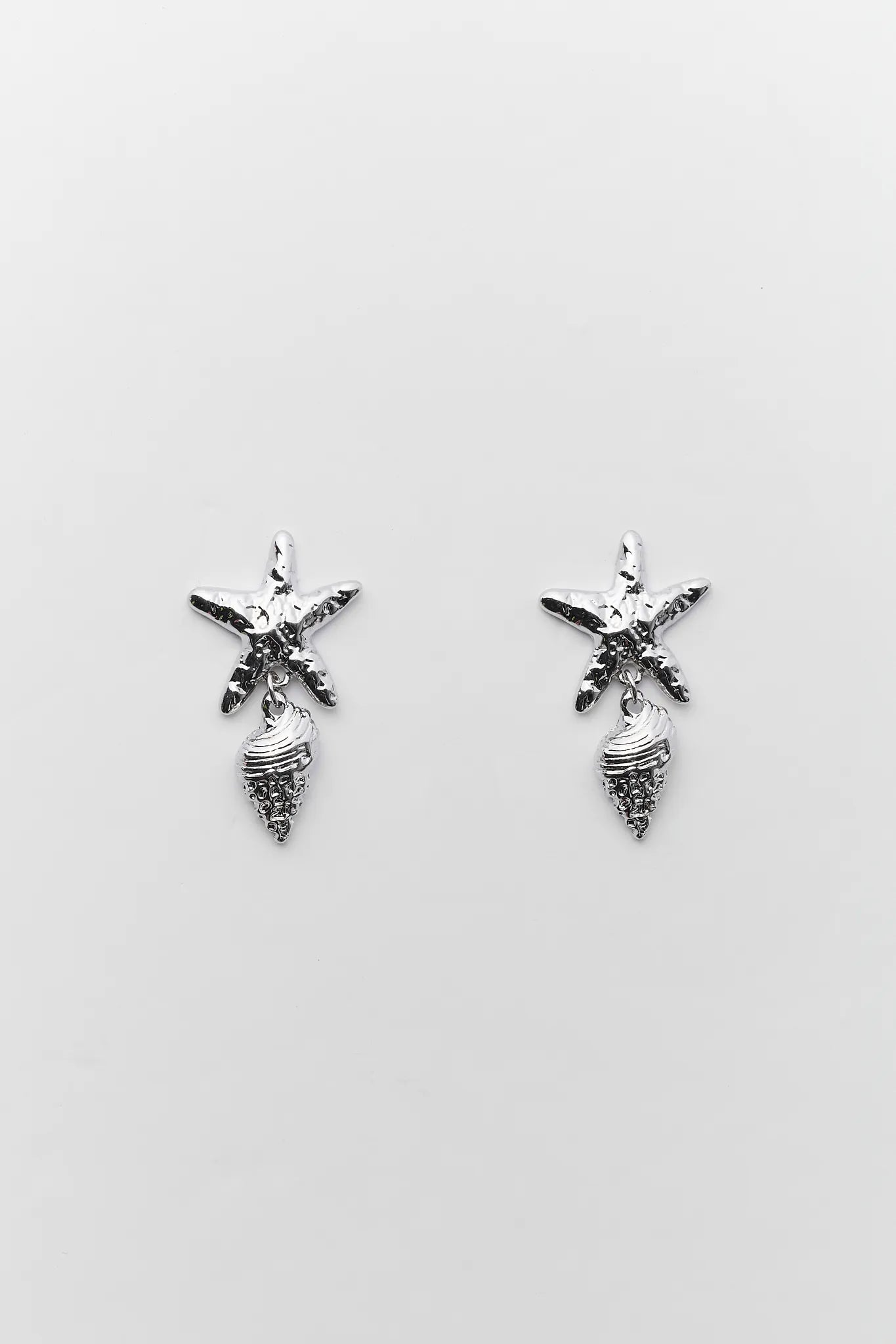 Pair of silver starfish and shell earrings on a light gray background