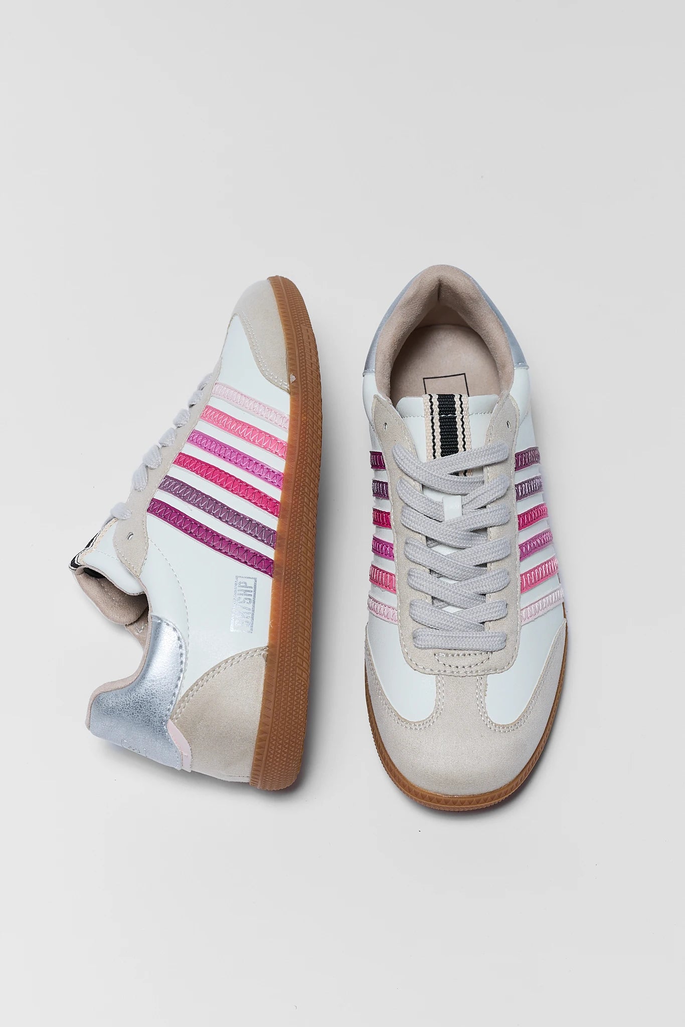 Pair of sneakers with colorful stripes on a light background