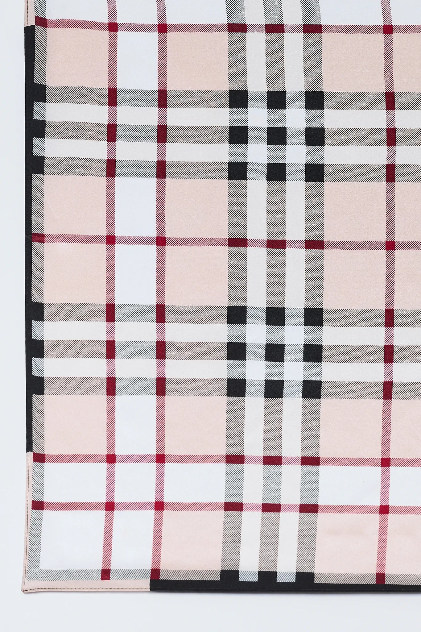 Plaid fabric with red, black, and white pattern on a white background