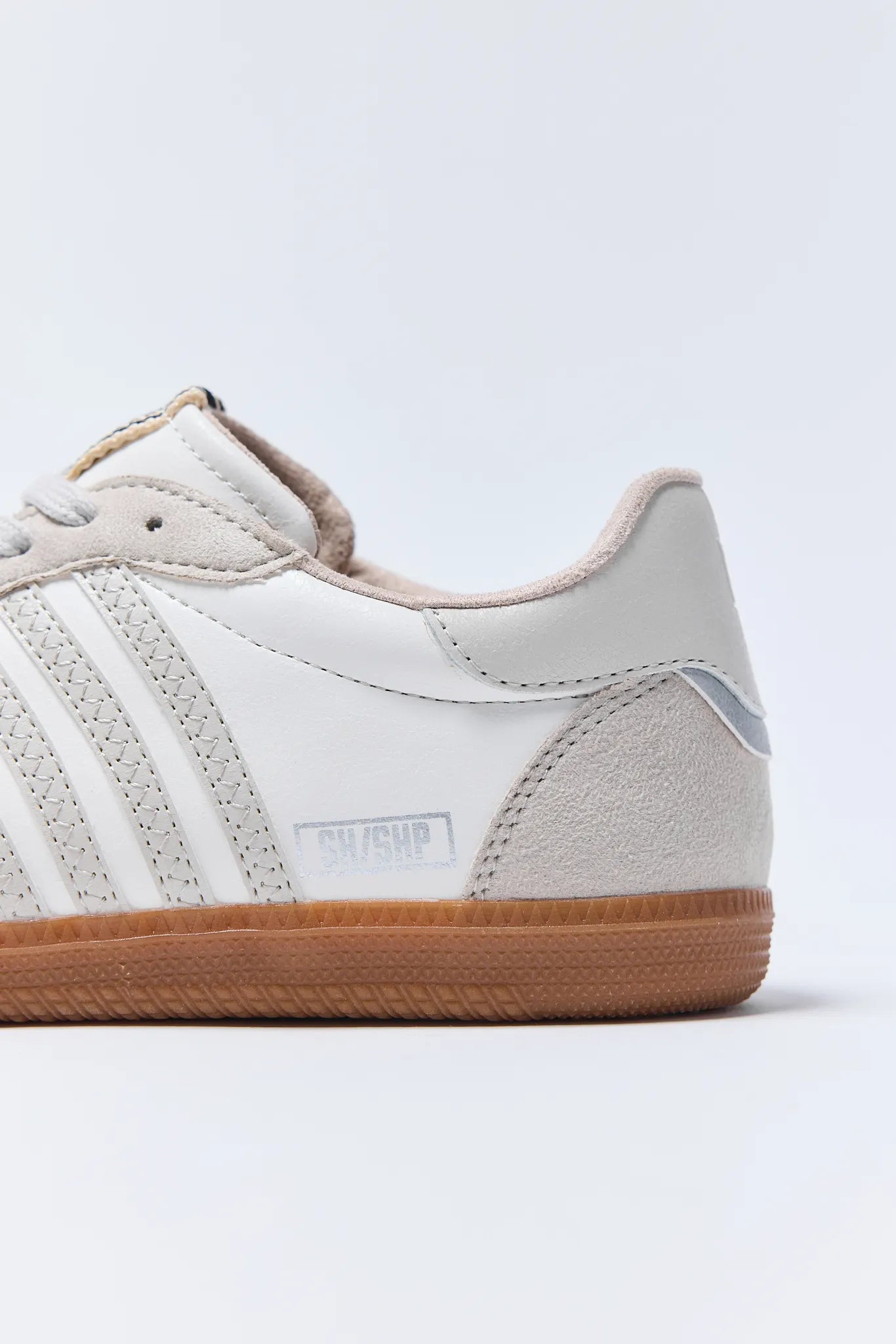 White Stevie Sneakers with brown sole on a light gray background