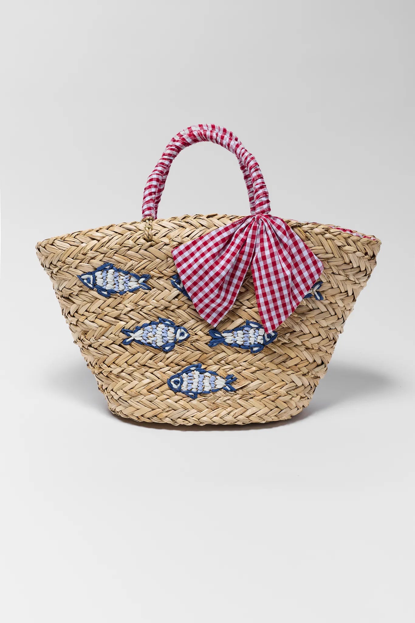 Woven bag with fish designs and a checkered ribbon on a light gray background