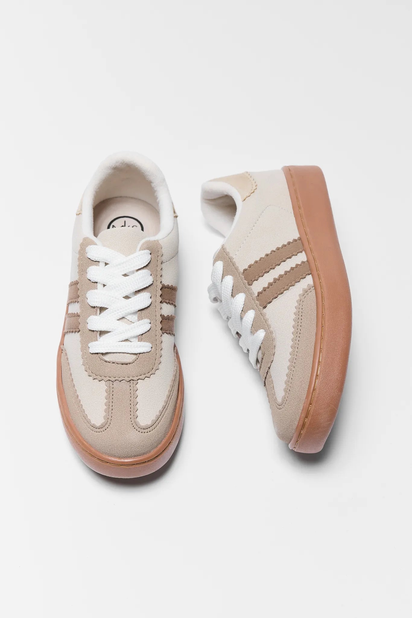 Pair of beige Sylvie Tan Striped Sneakers with white laces on a light gray background