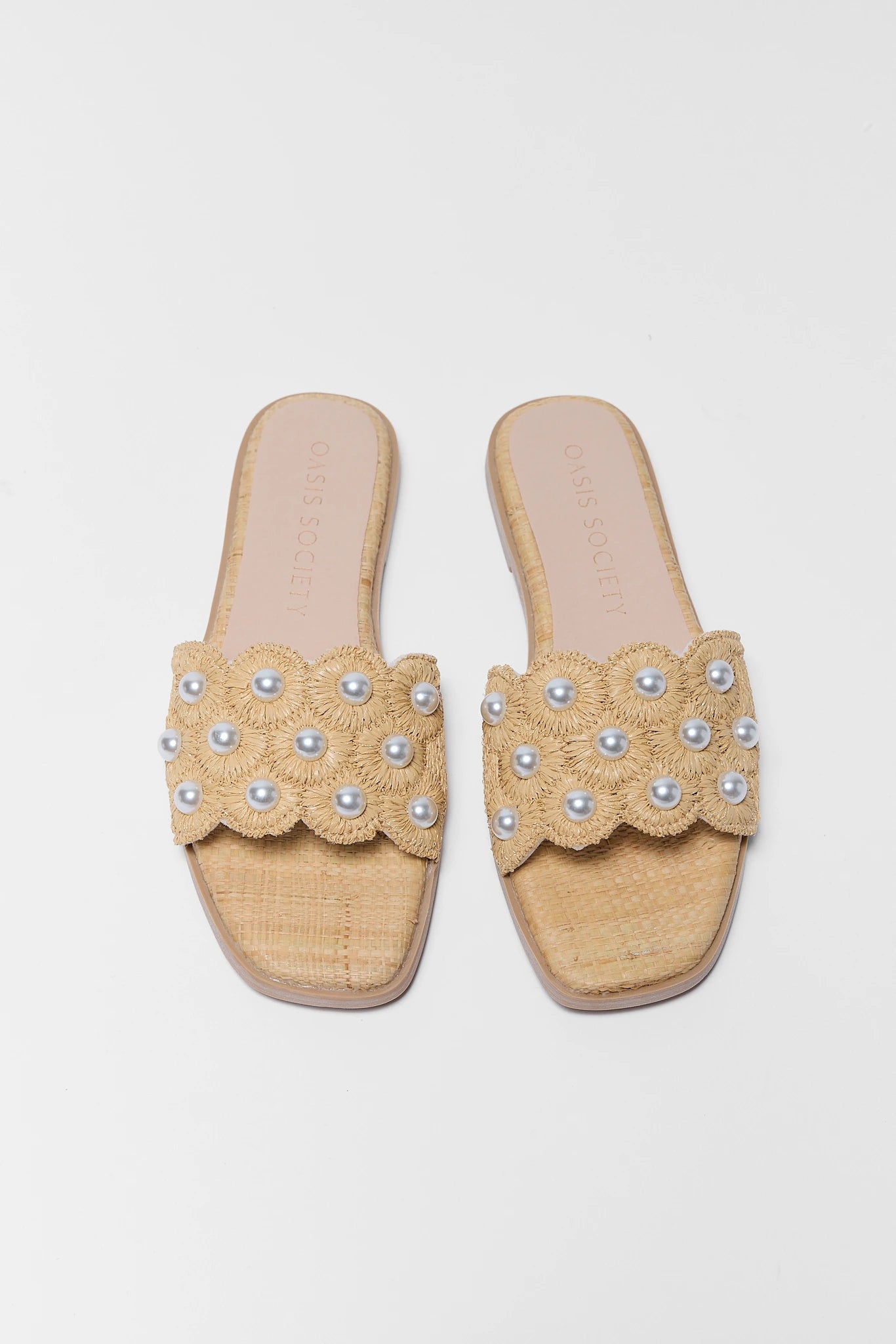 Beige sandals with pearl embellishments on a light background two