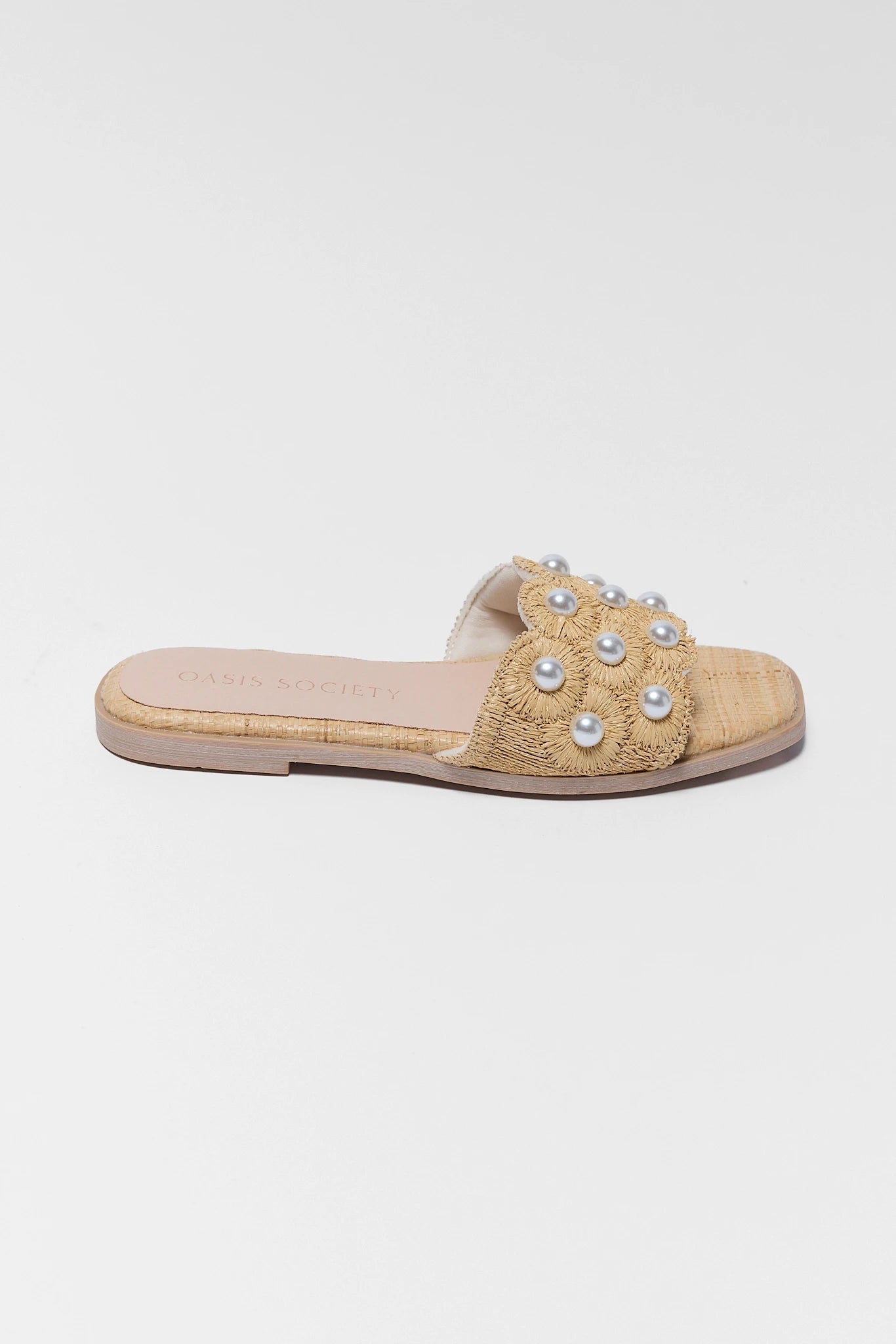Beige sandal with pearl embellishments on a light gray background
