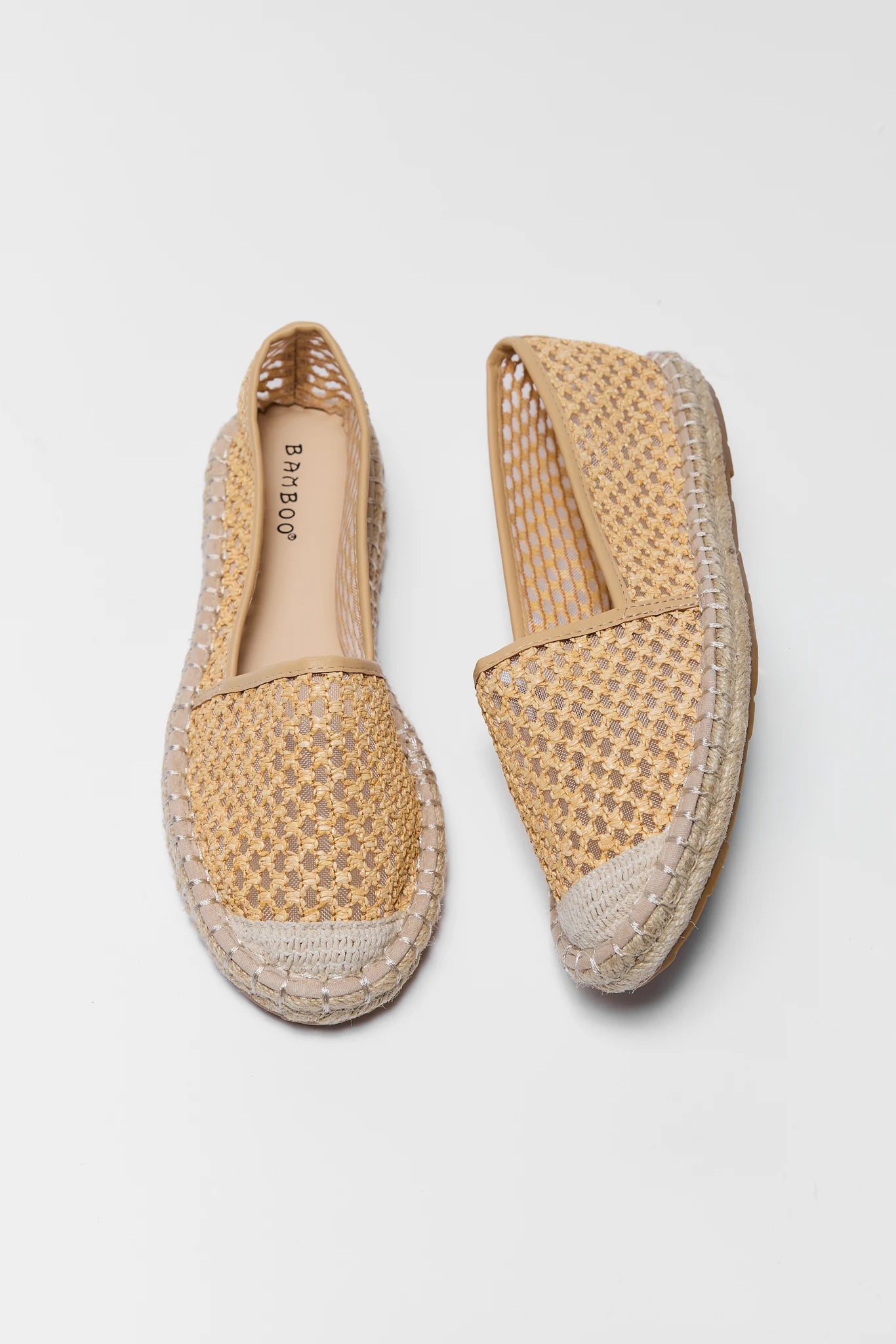 Pair of woven espadrilles on a light gray background
