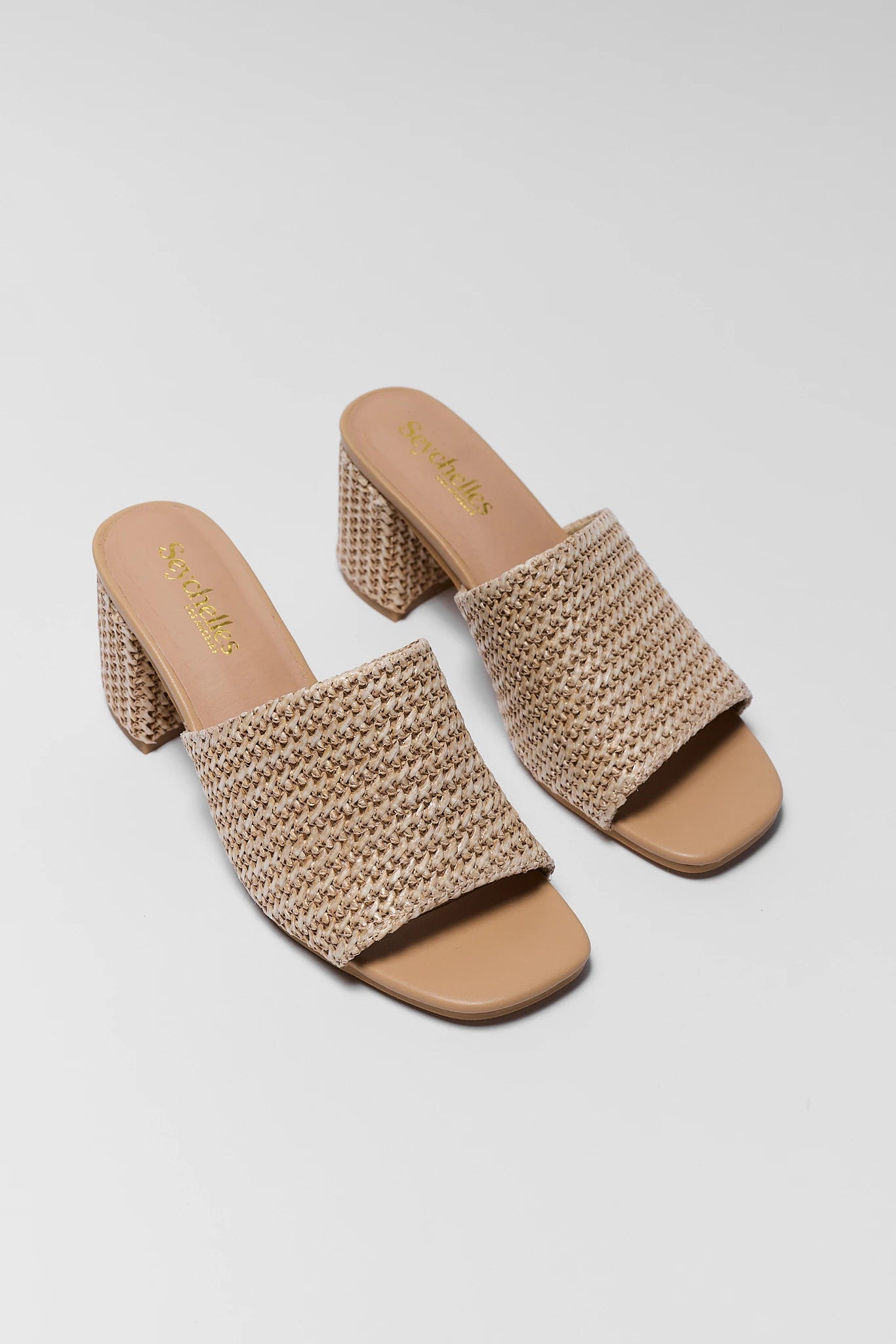 Pair of beige woven sandals on a light gray background two