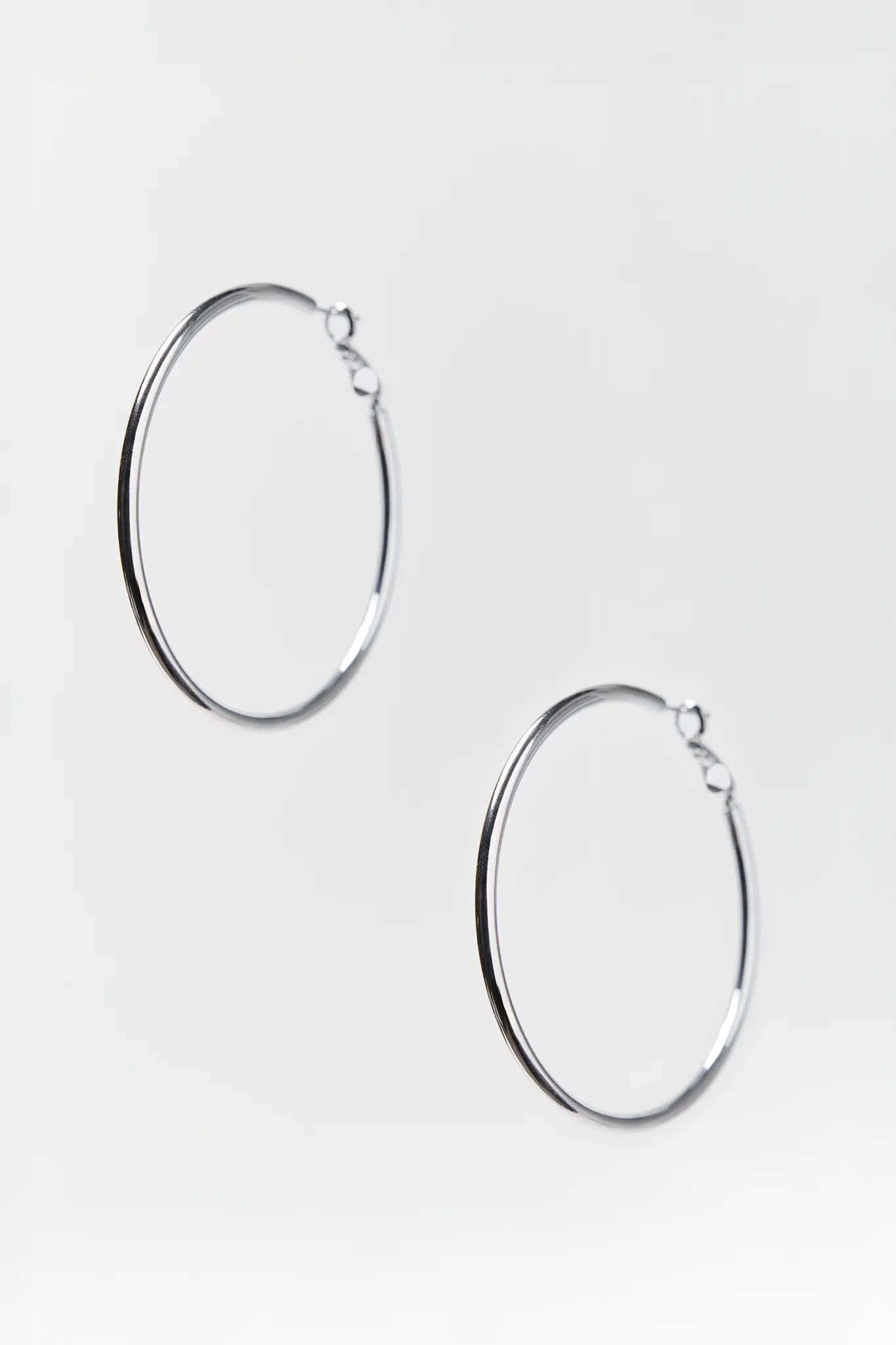 Pair of silver hoop earrings on a white background