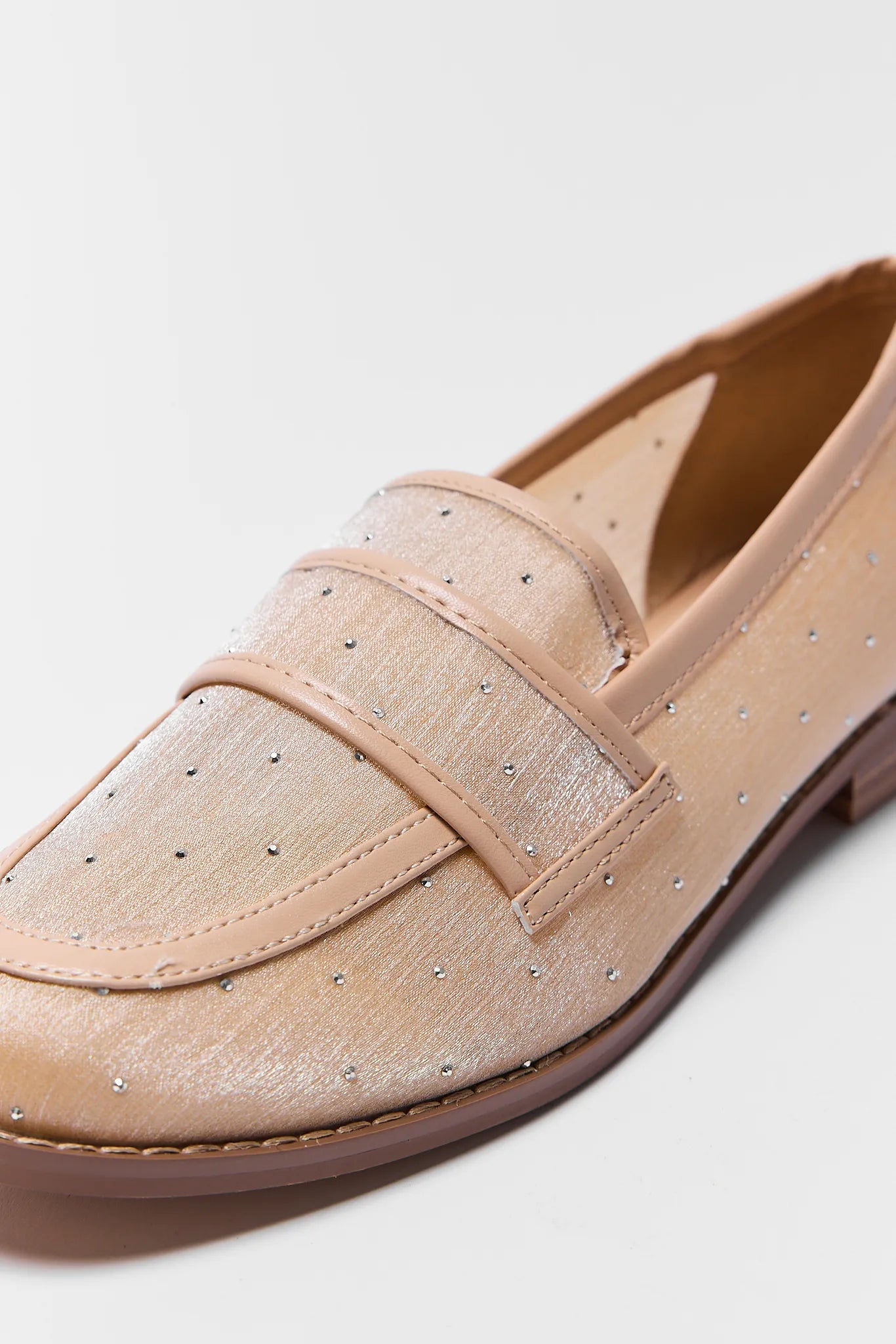 Beige loafer shoe with a strap on a light gray background