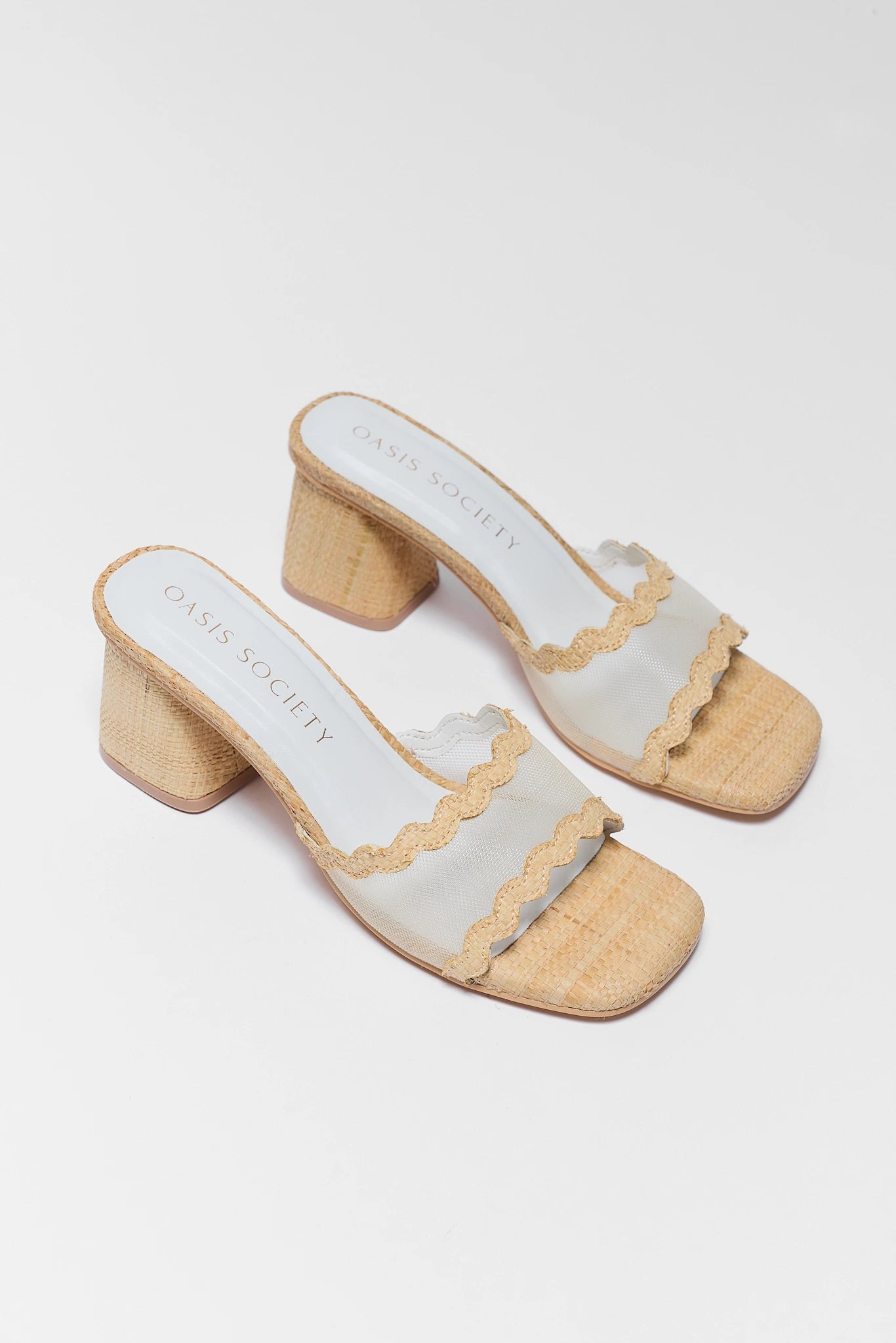 Pair of two beige sandals with wooden block heel on a background