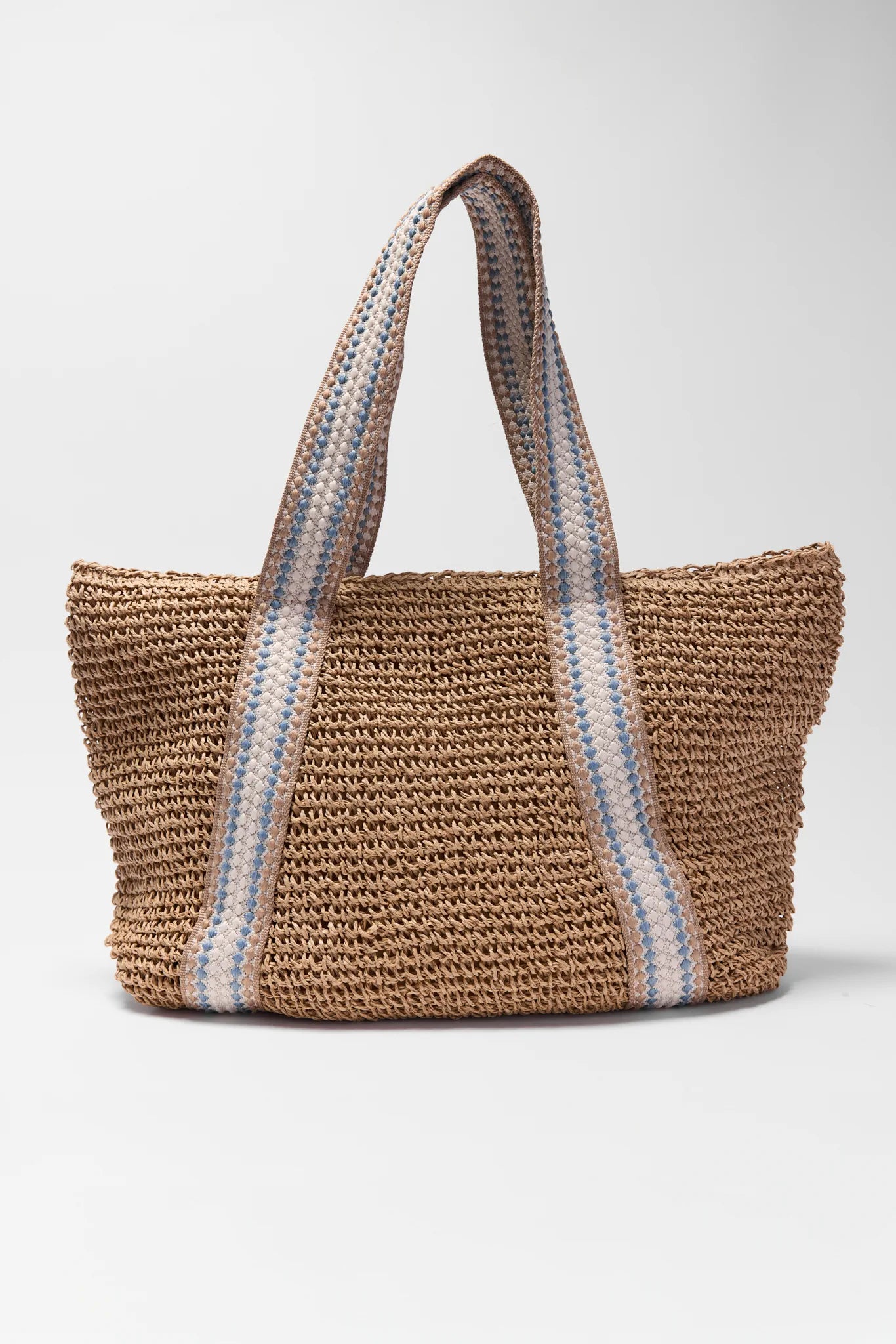 Woven straw bag with striped handle on a white background