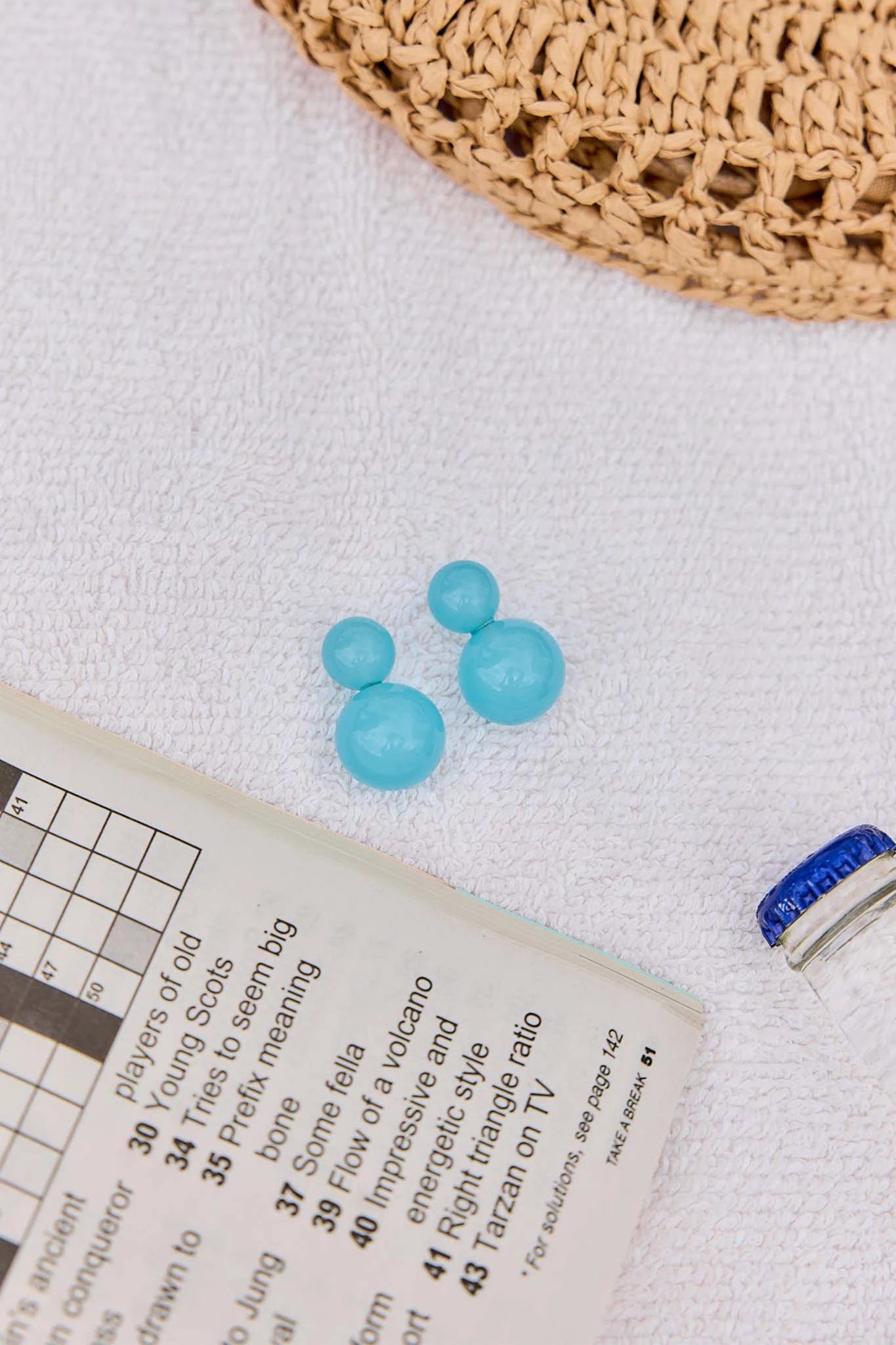 Blue beads on a newspaper with a woven basket in the background