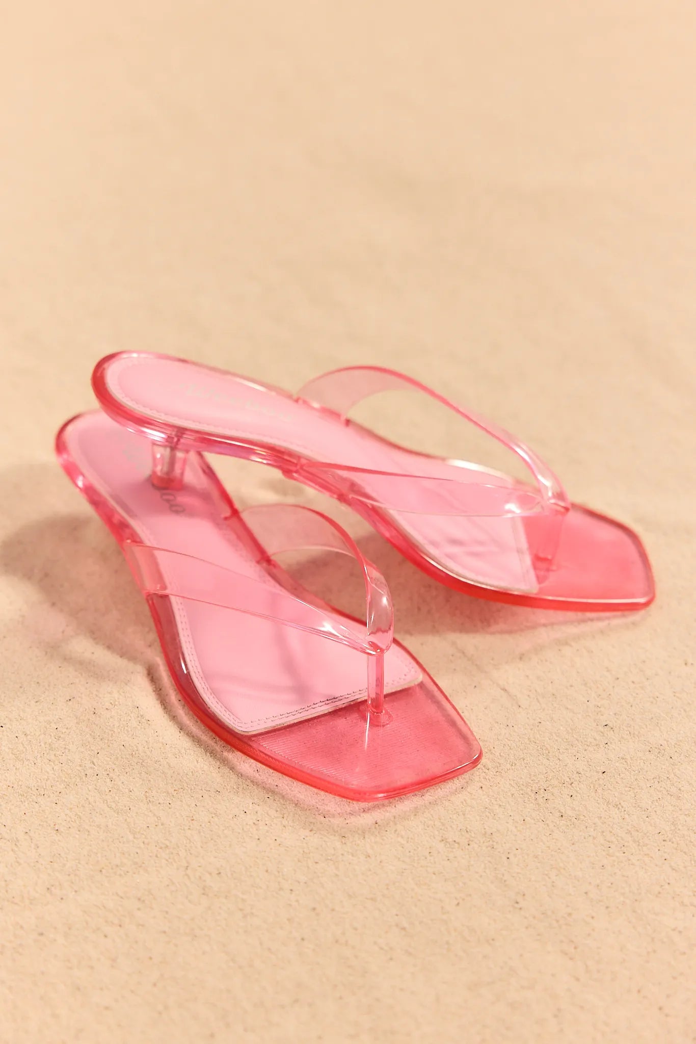 pink jelly heels on sand background