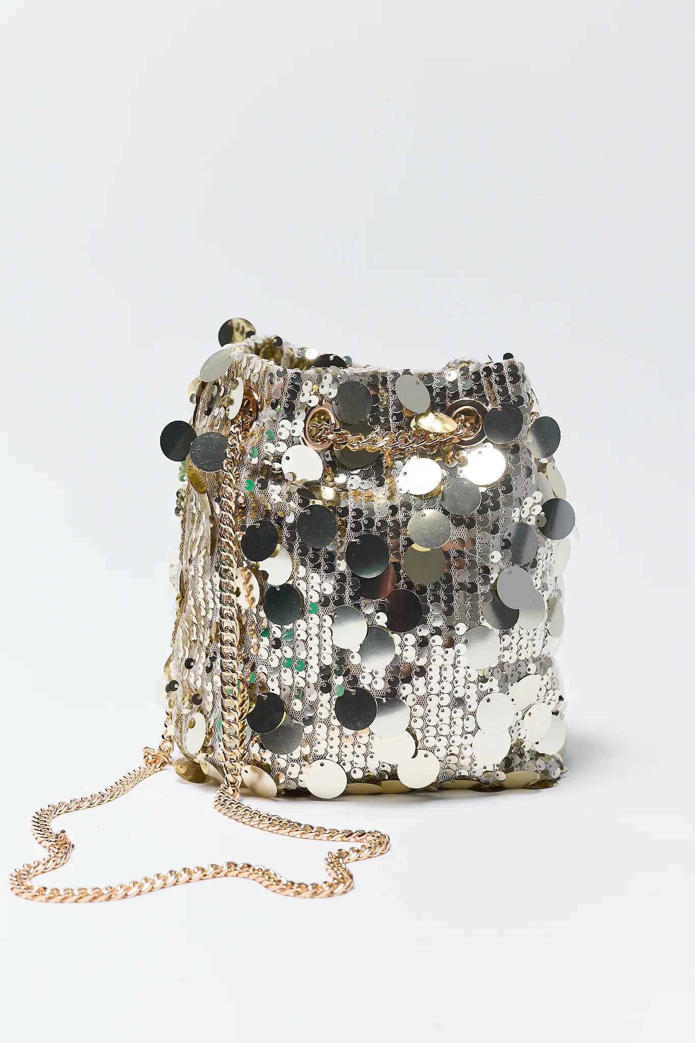 Sparkling sequin handbag with a chain strap on a light gray background