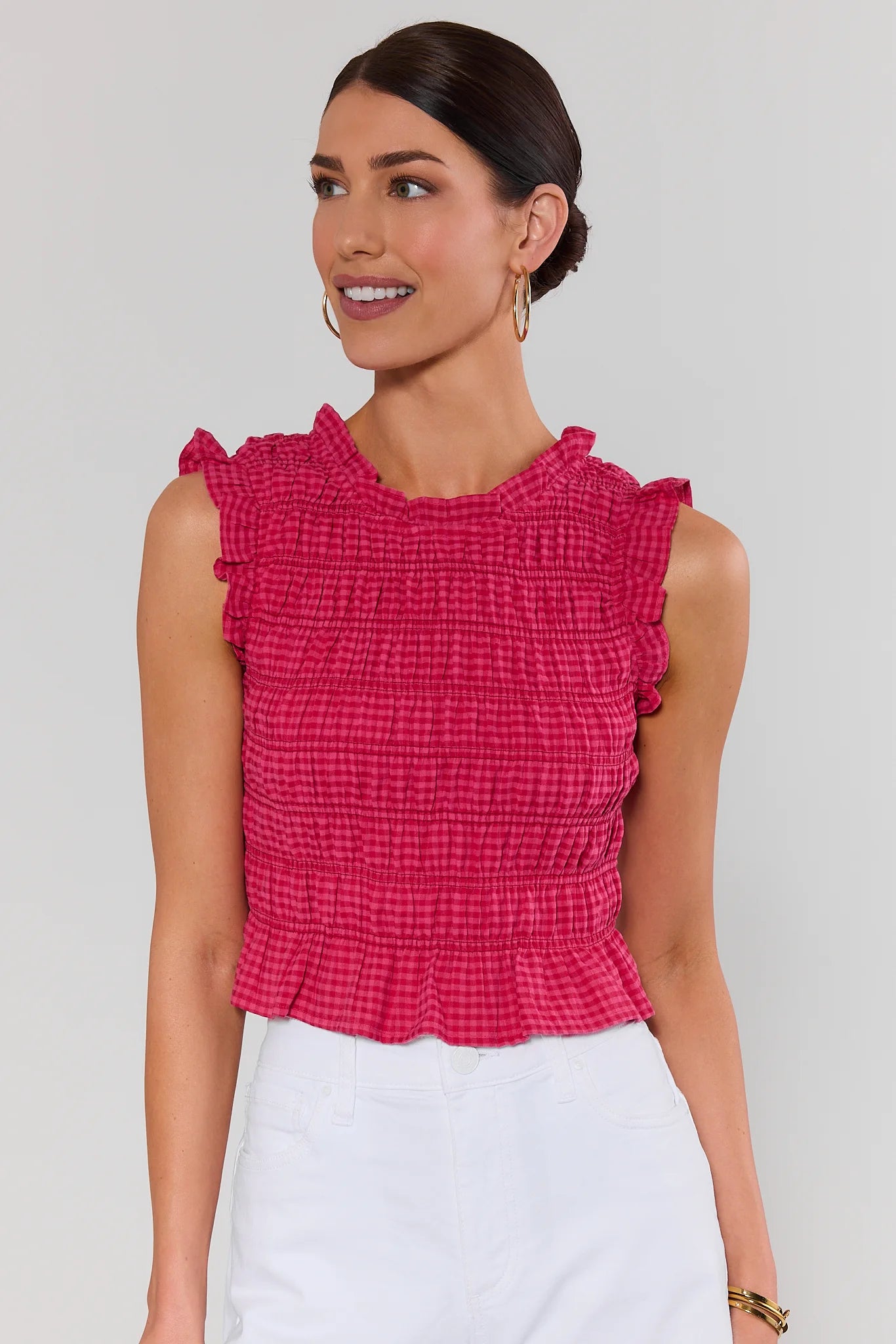 Woman wearing a red ruffled top against a plain background