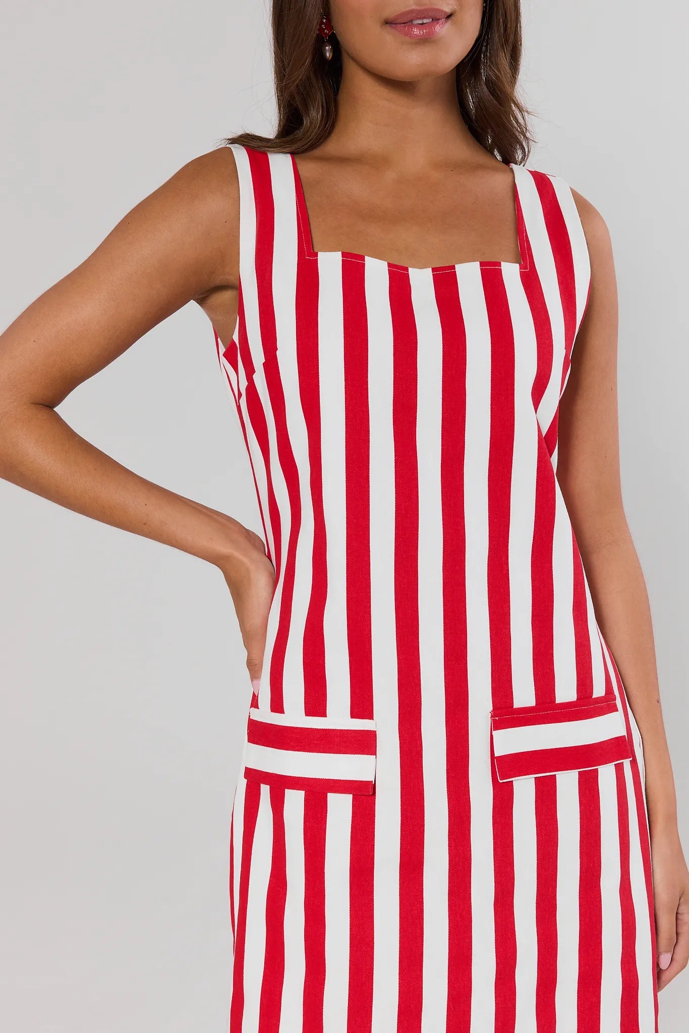 close up Red and white striped dress worn by a model on a plain background