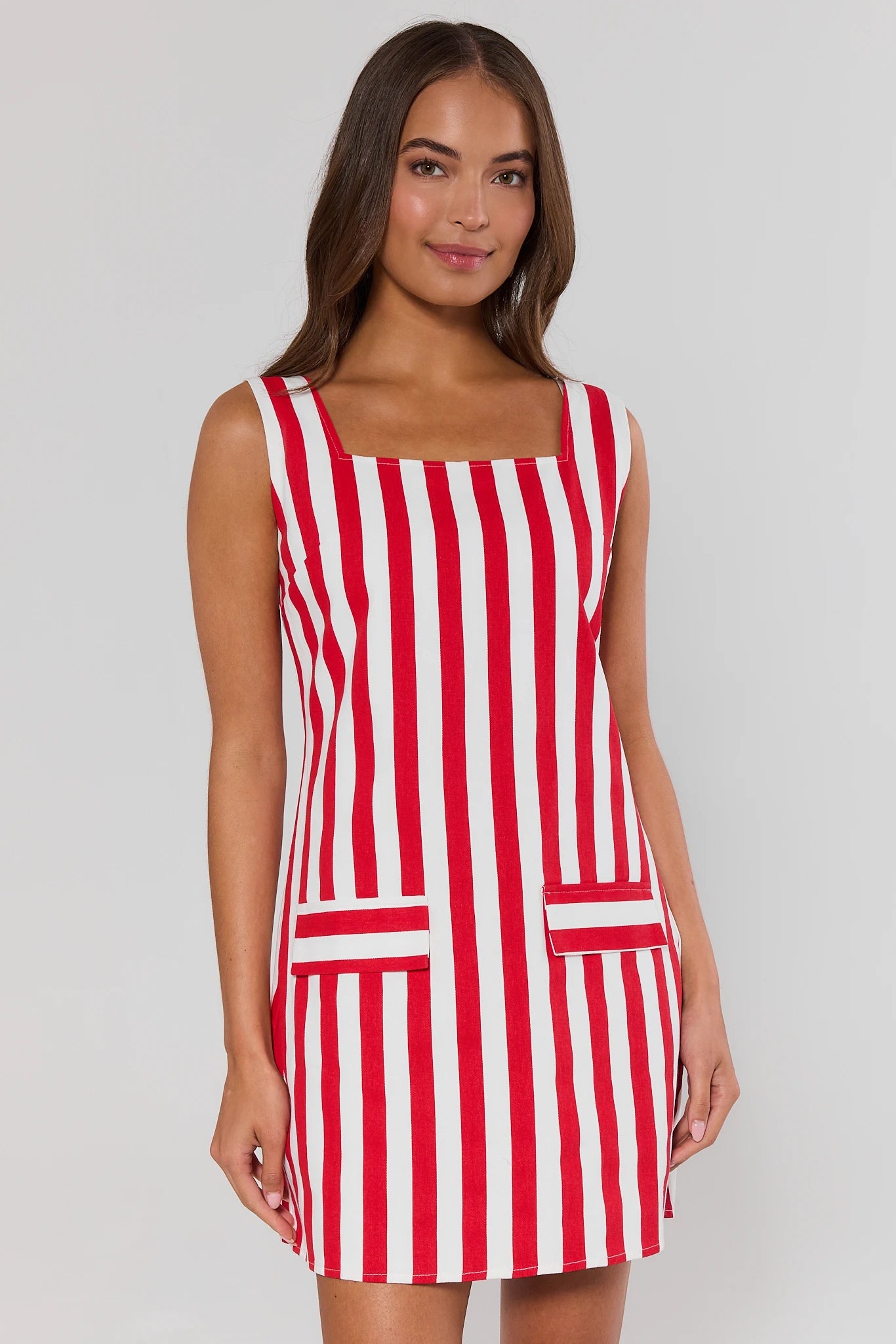 Woman wearing a red and white striped dress on a plain background