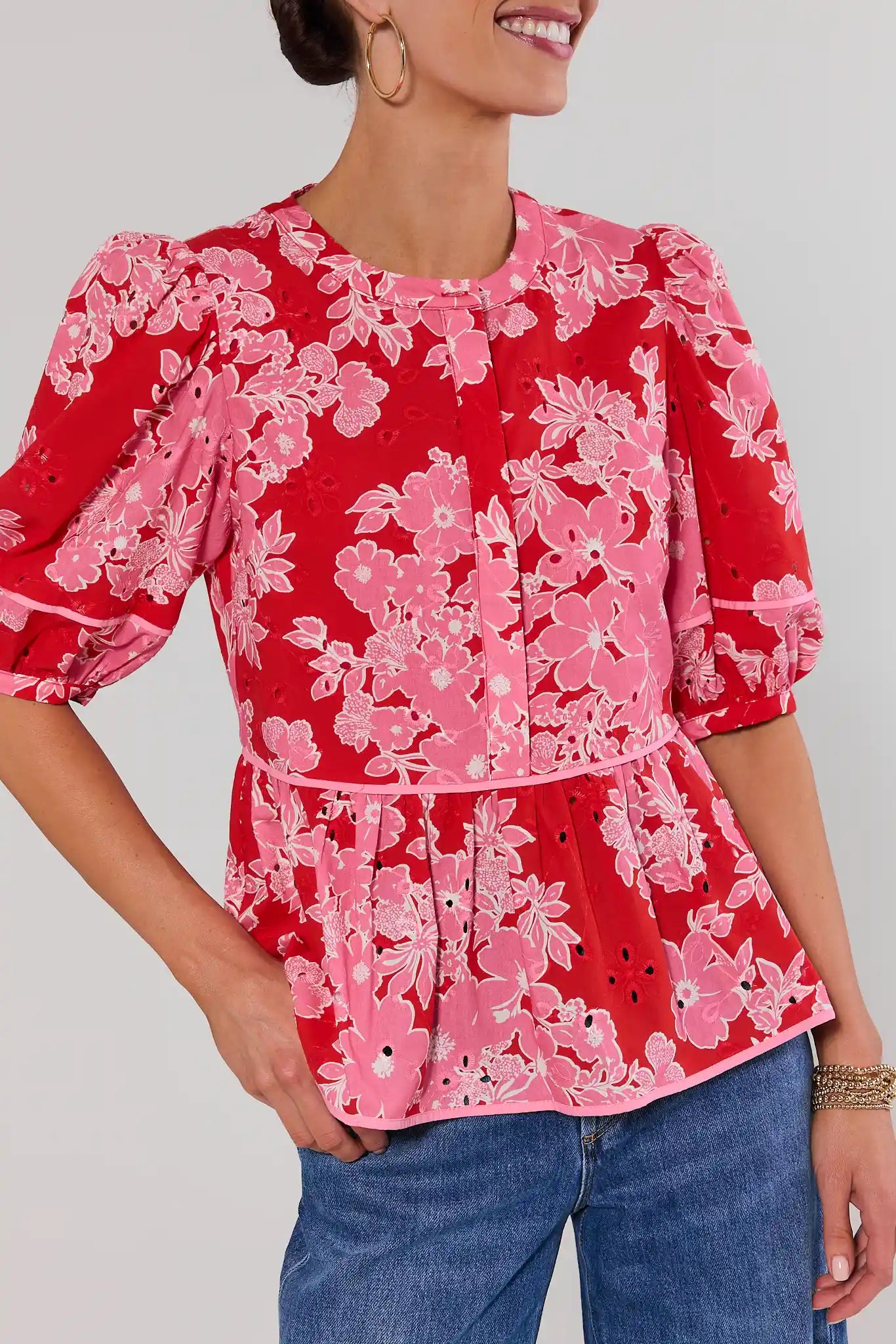 close up woman wearing red floral eyelet peplum top on white background