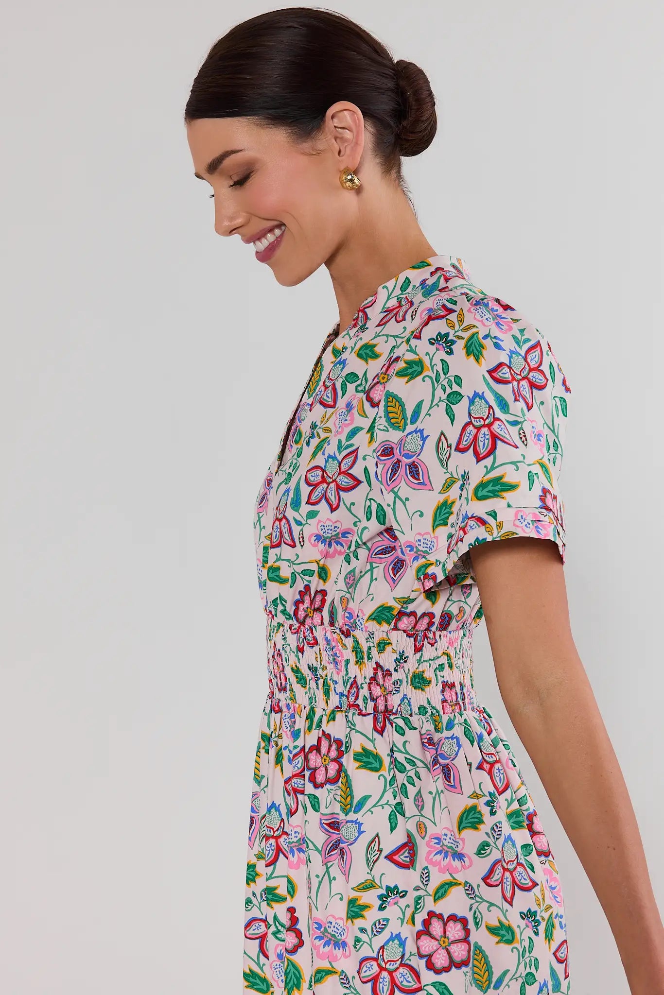 close up Woman wearing a colorful isabella floral dress against a plain background