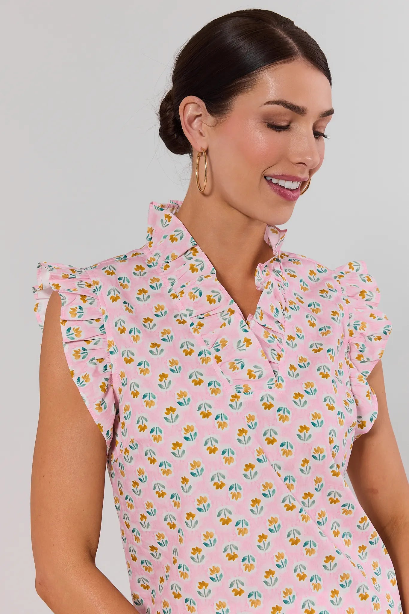 close up Woman wearing a pink floral dress against a plain background