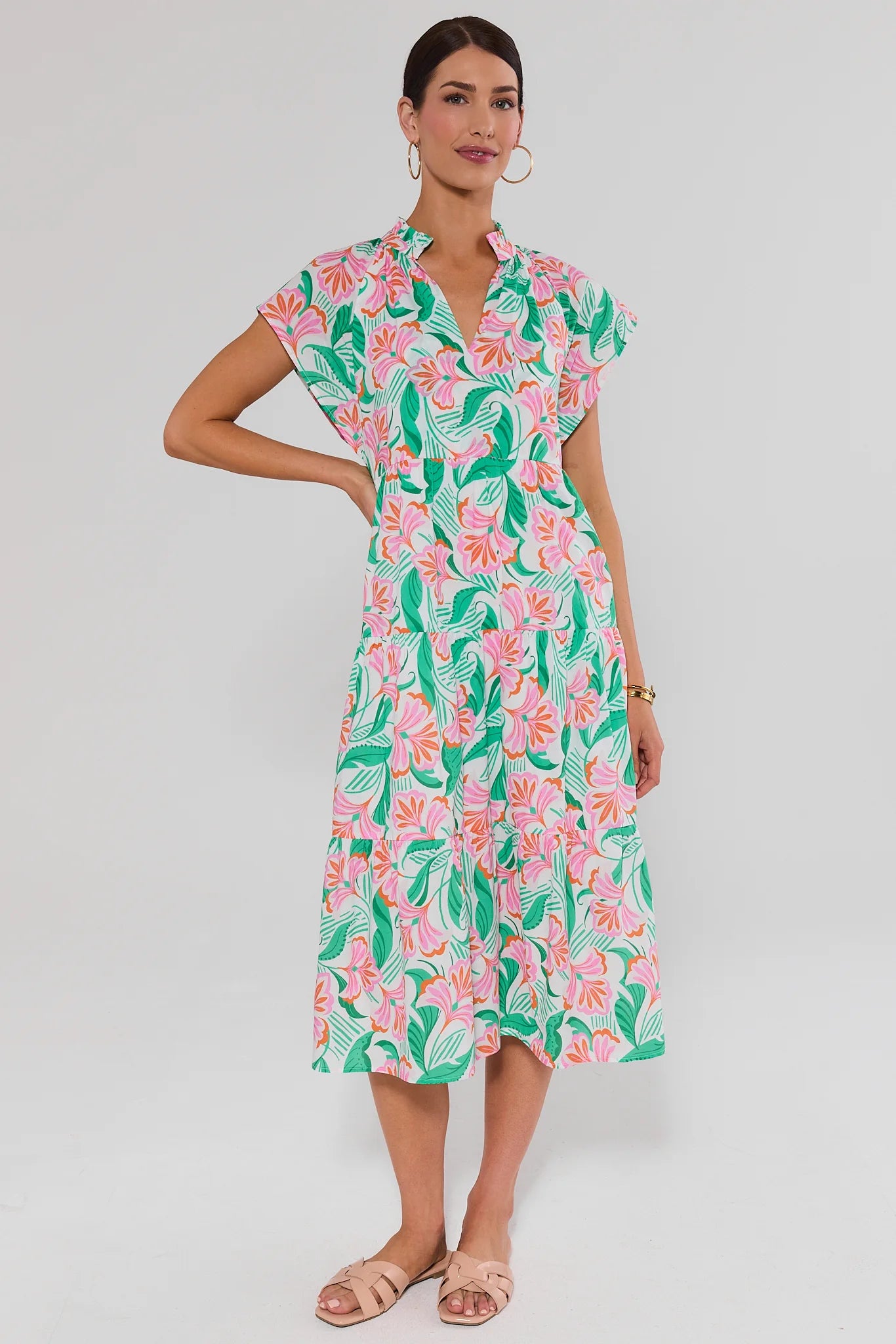 Woman wearing a floral dress standing on a plain background