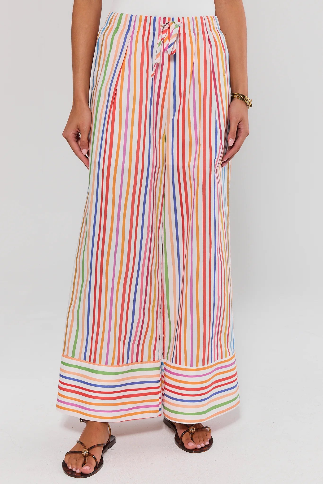 Multicolored striped pants worn by a person on a white background