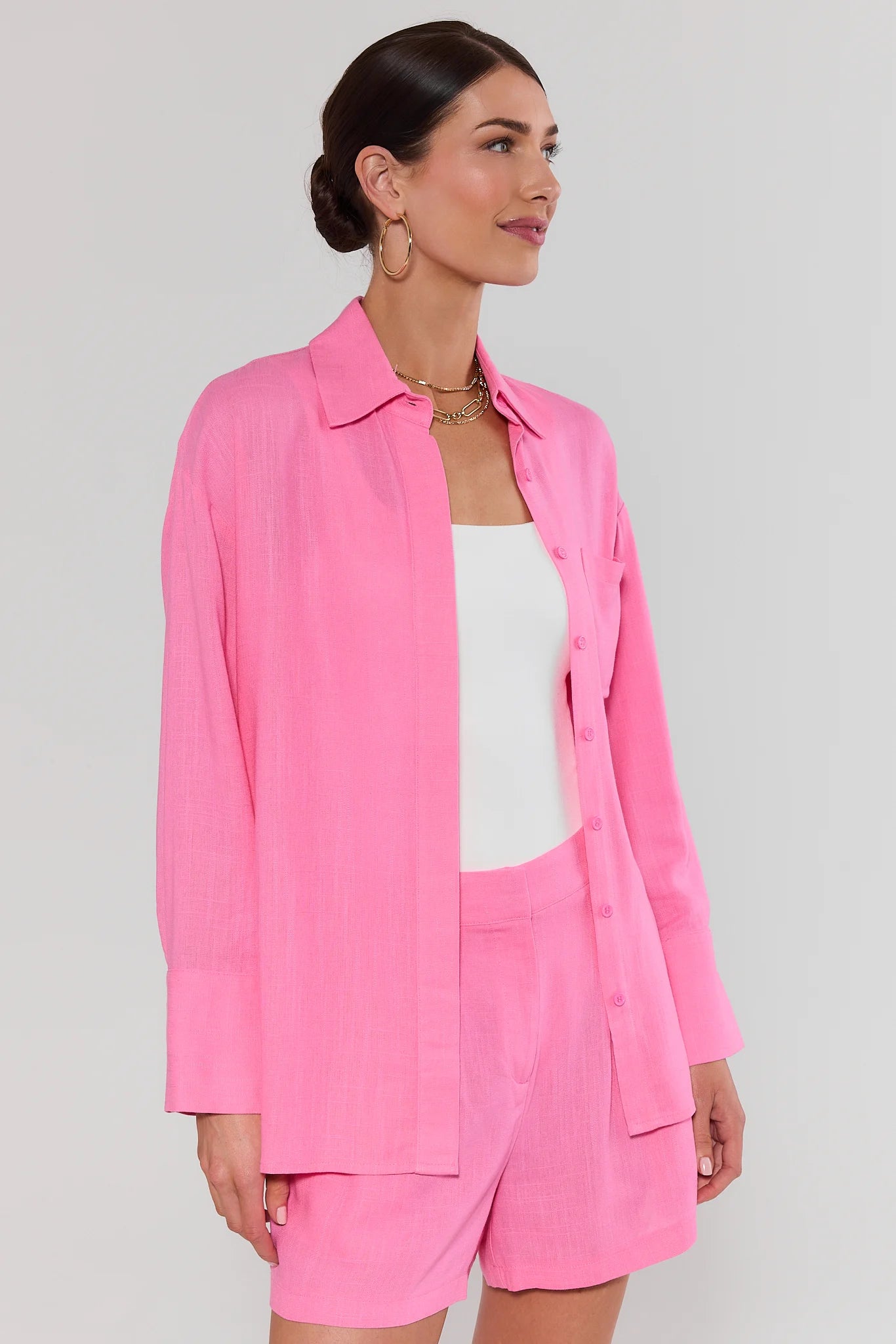 side shot Woman wearing a pink outfit with a white background