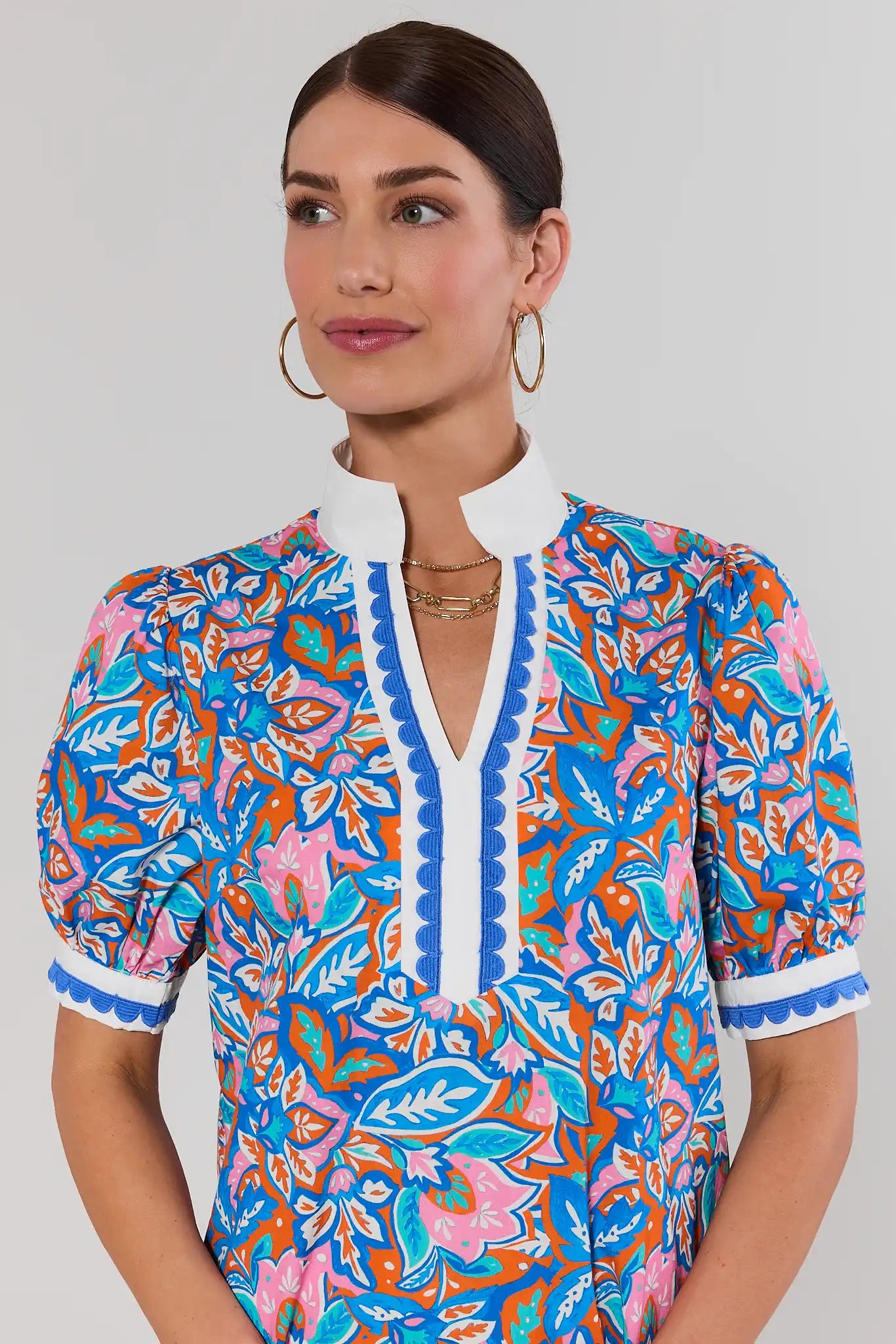close up Woman wearing a colorful patterned dress with a plain background
