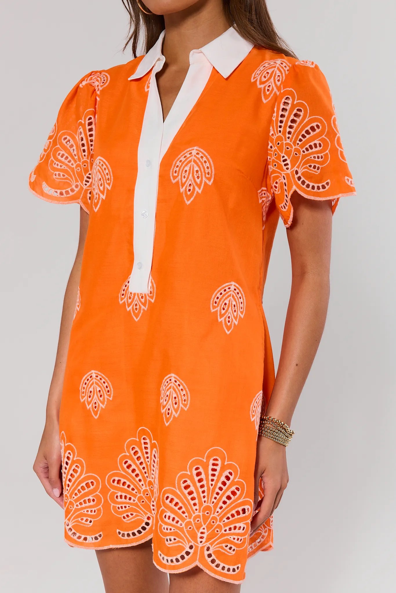 Orange dress with white pattern on a plain background close up 