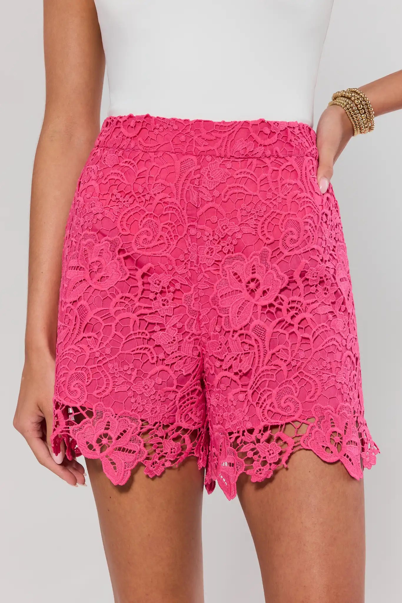 Pink lace shorts worn by a person on a light gray background