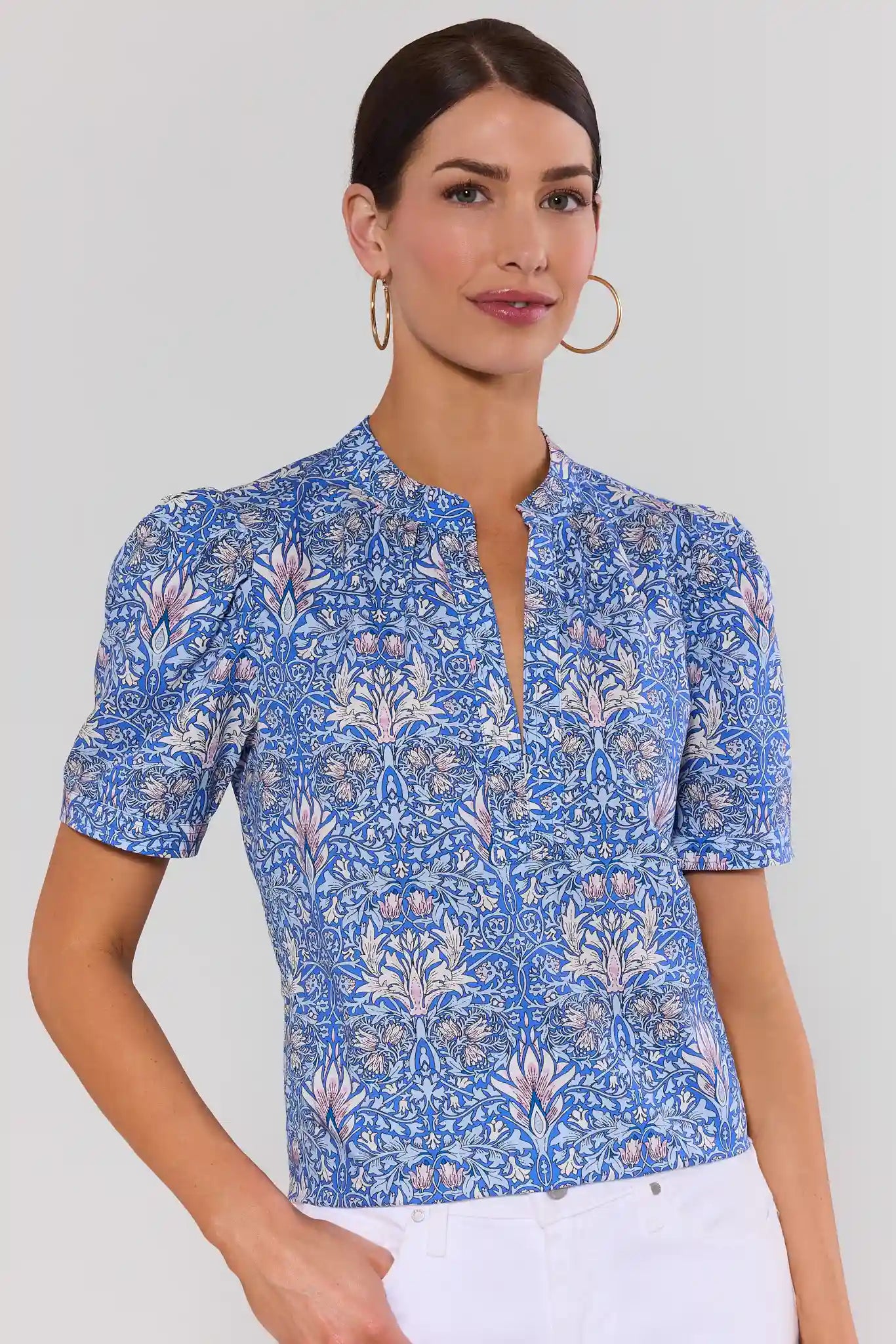 Woman wearing a blue floral blouse against a plain background