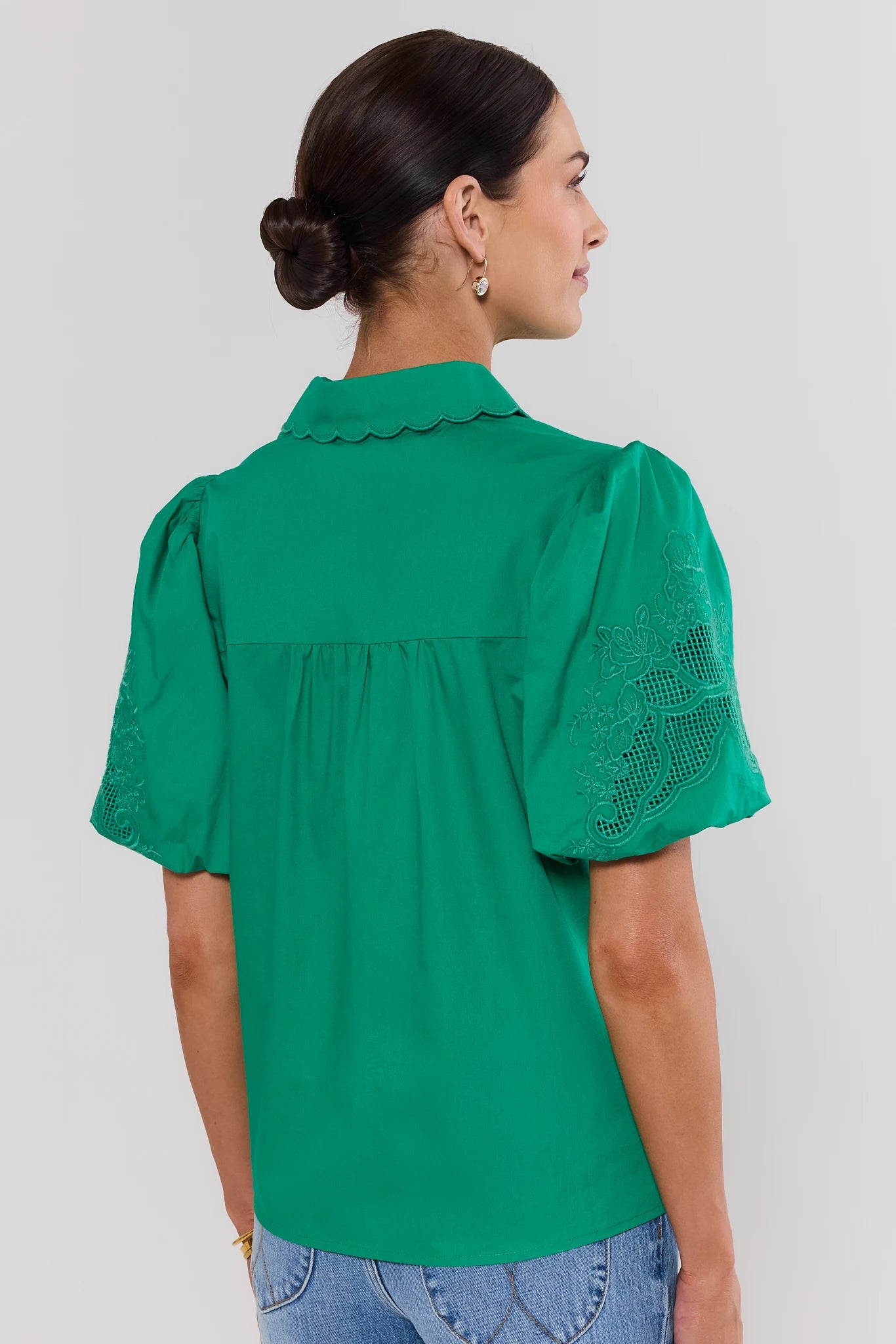  woman wearing green amelia eyelet top on white background standing