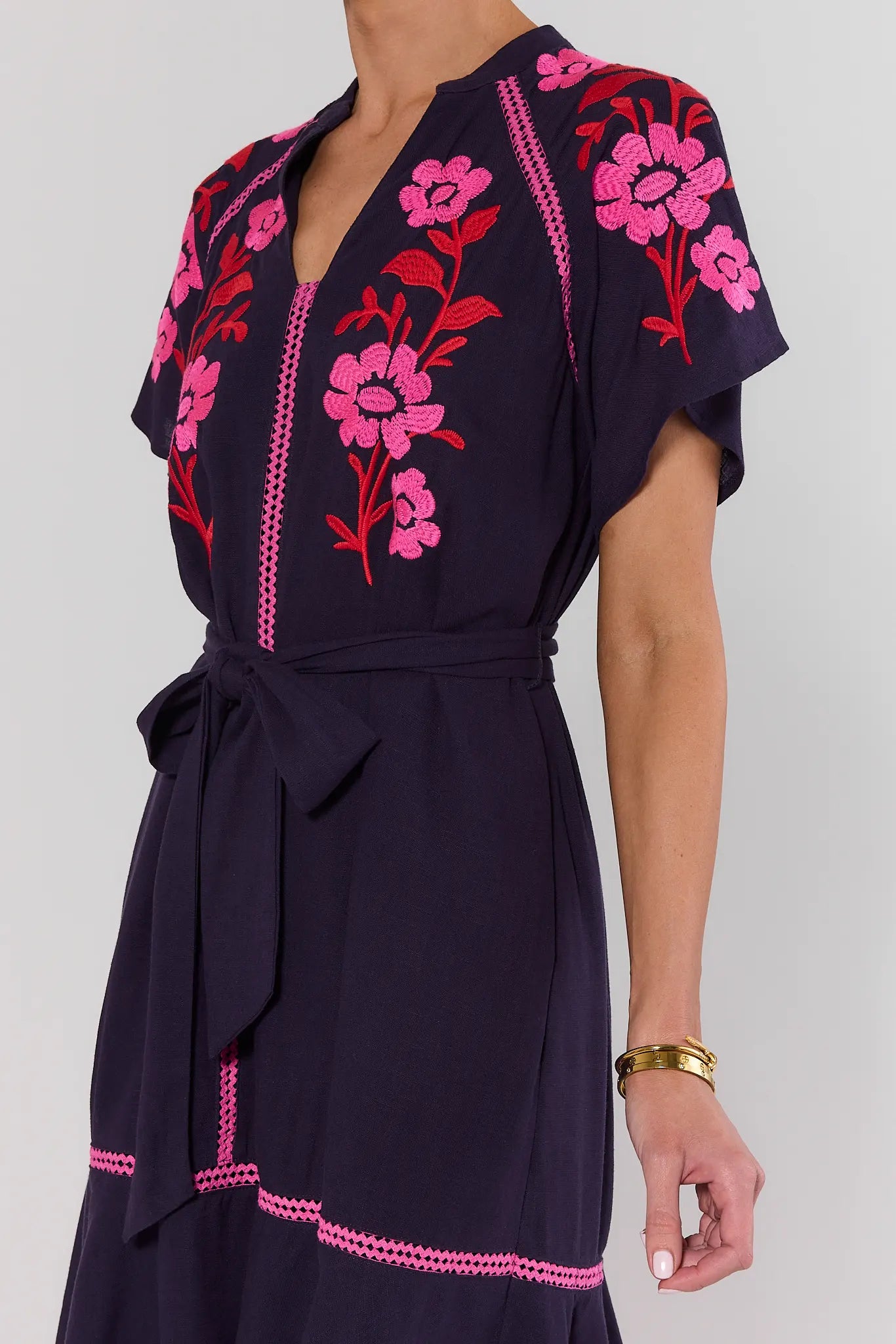 Navy dress with pink floral embroidery on a white background lifestyle
