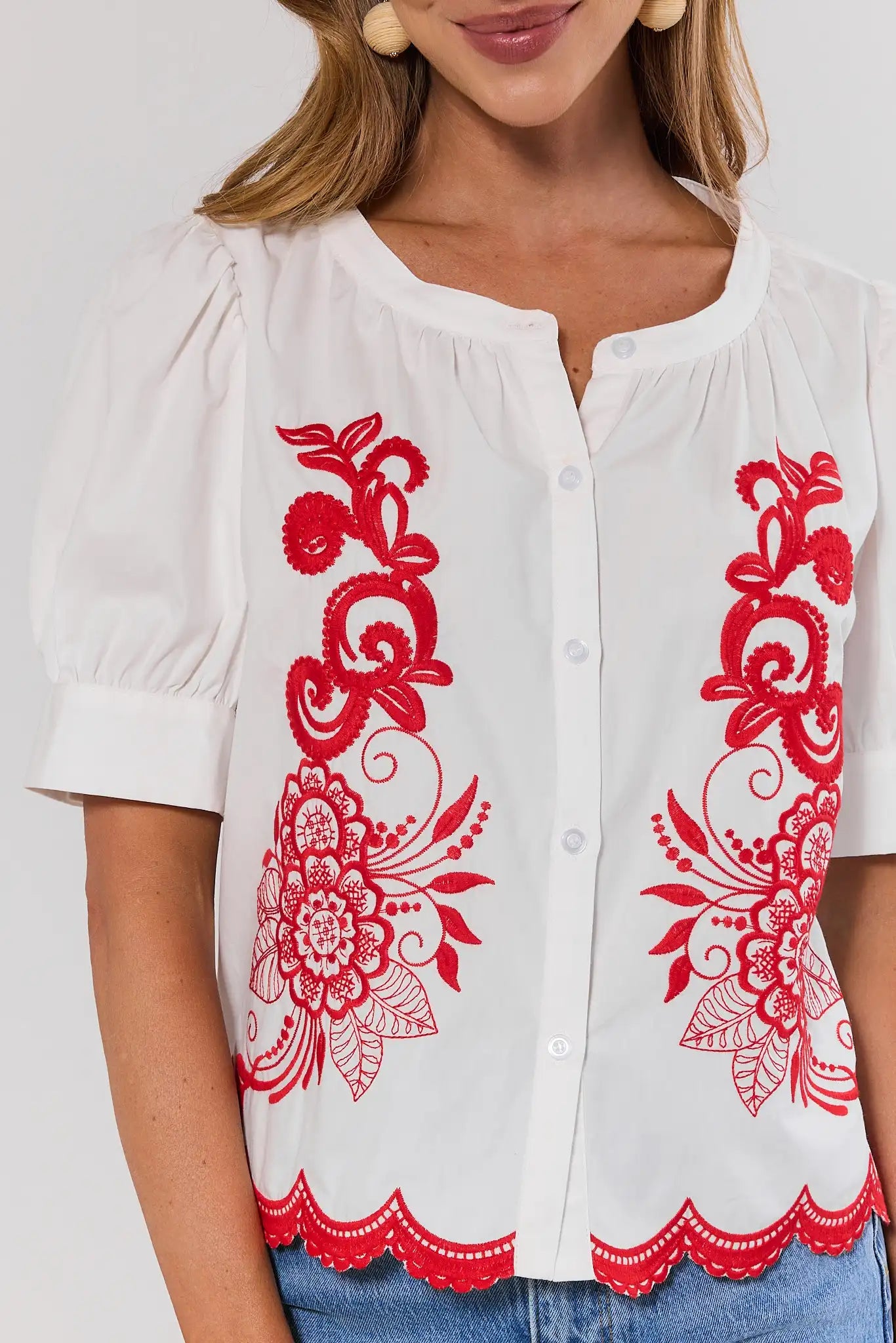 close up White blouse with red floral embroidery on a white background