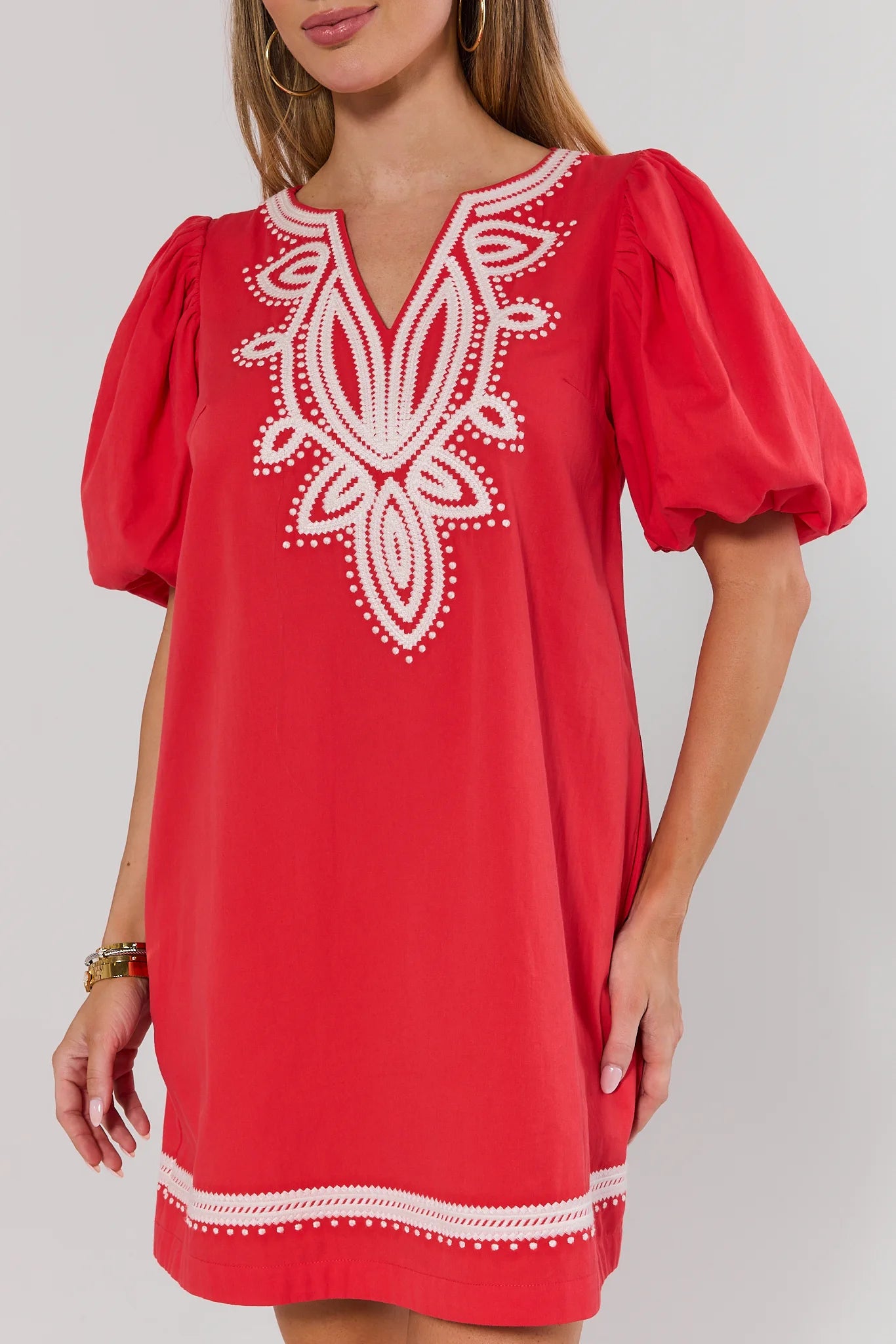 Red dress with white embroidery on a plain background close up 