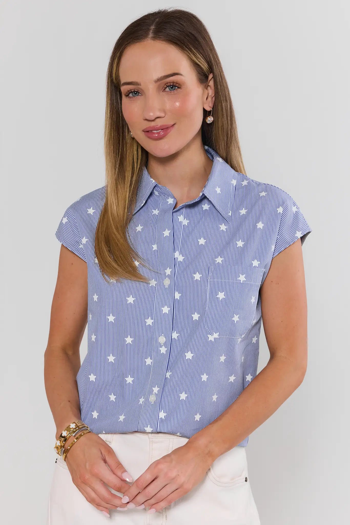 Woman wearing a blue shirt with star pattern against a plain background